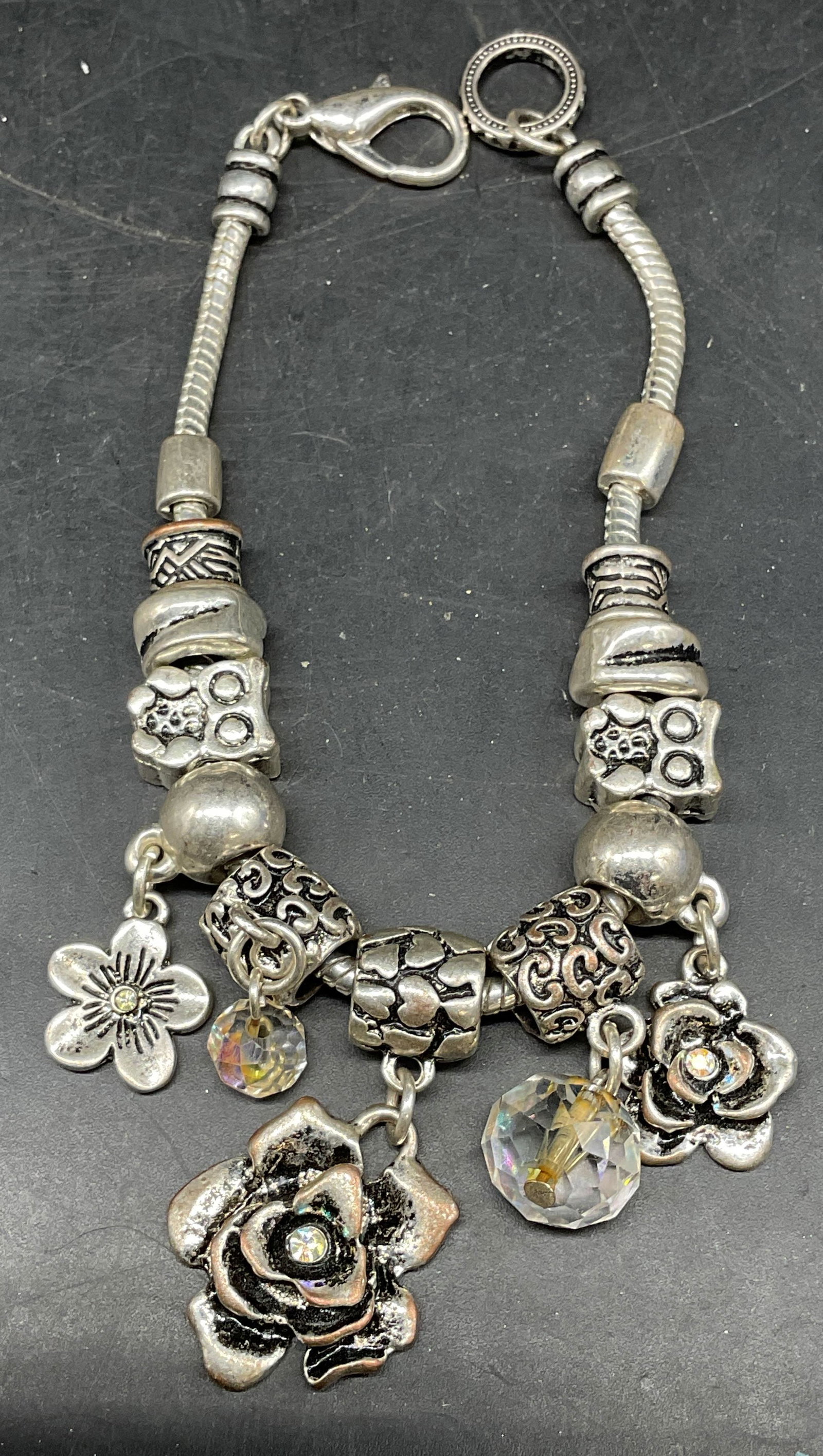 Silver Tone Flower Owl Crystal Charm Bracelet: Silver tone charm bracelet with flower and owl charms and crystal accents. Measures approx. 8 inches long. Some scratching. Jewelry, estate jewelry, costume jewelry, cocktail jewelry, fashion