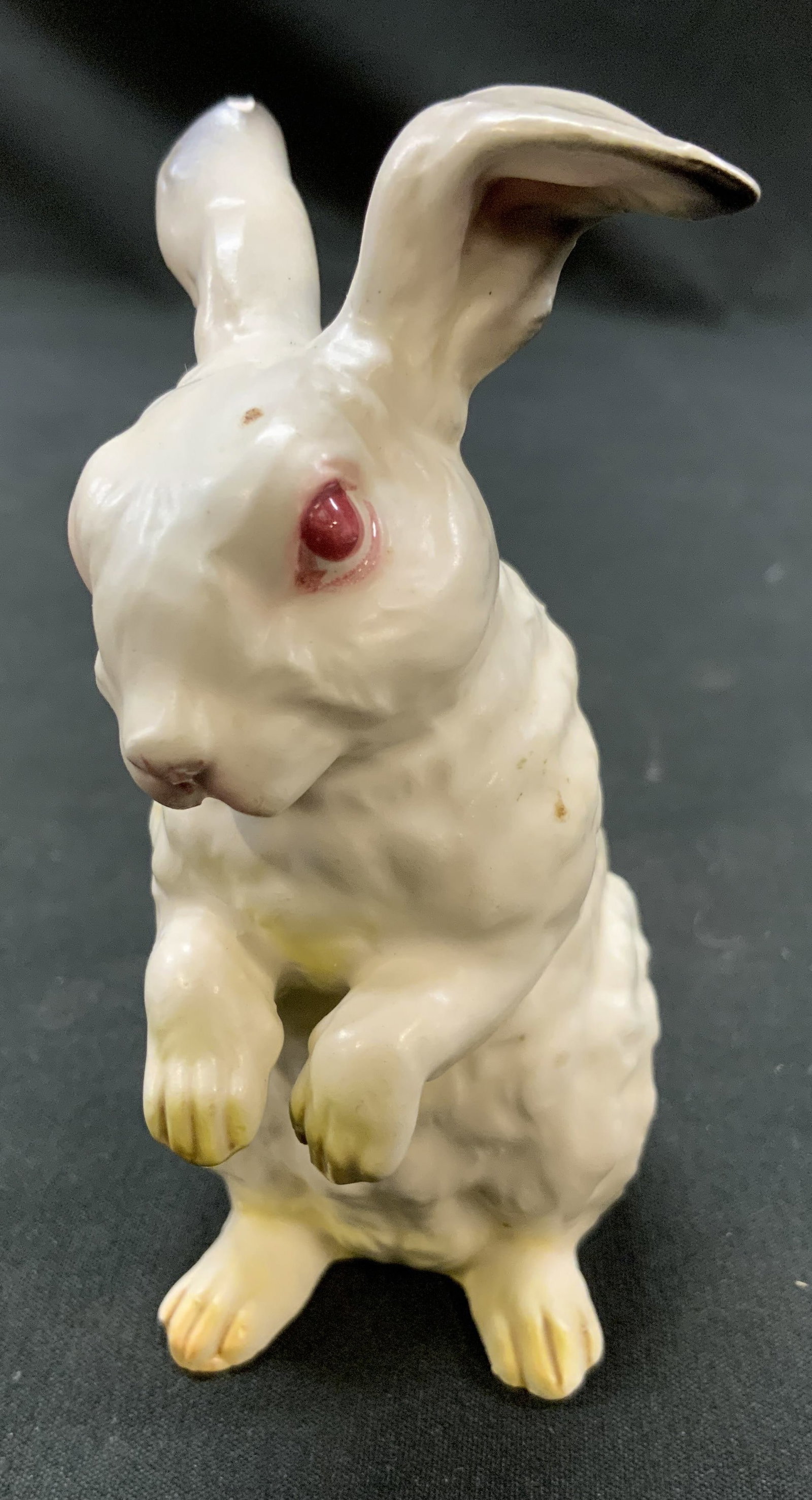 Vtg Japan Porcelain Standing White Rabbit Fig.: Vintage Mid Century Porcelain White Standing Red Eye Rabbit Figurine. Made in Japan. Semi gloss white porcelain glaze. Hand painted details on paws, ears, face. Measures approx. 4in x 1 x 2in Surface 