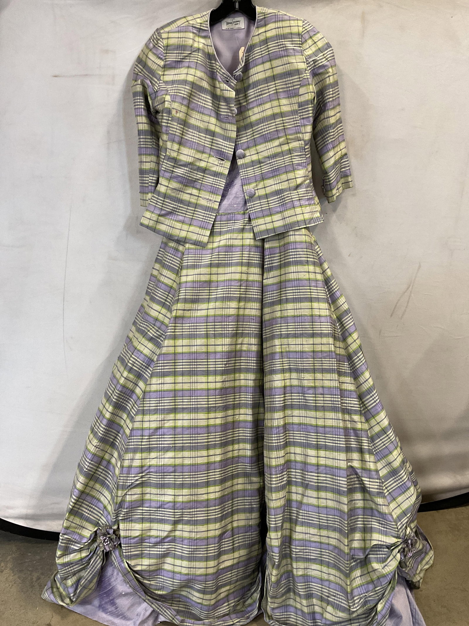 Nancy Sinoway dress and jacket set Raw Silk: Nancy Sinoway dress and jacket set in raw silk. Dress has a purple bodice with green and purple plaid straps that tie and can be adjusted for size. The skirt is the same purple and green plaid and
