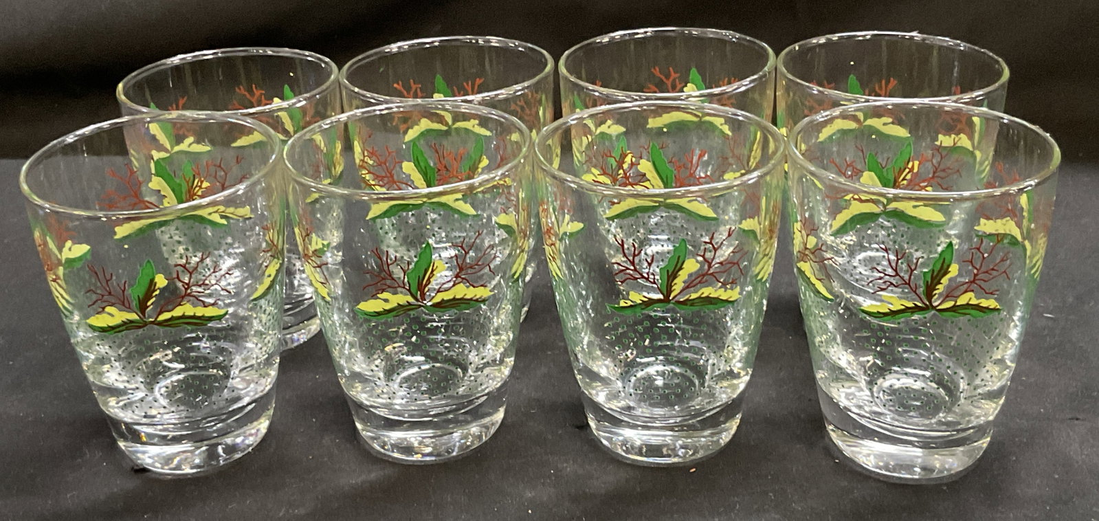 St8 MCM Libbey Glass Botanical Design Glasses: Set of 8 Mid-Century Modern Libbey Glass Botanical Design Lowball Glasses. Bright Green and Yellow Leaves Paired with Brown Branches Design. Green Dotted Pattern. L Mark on Bases. Some Residue on Base