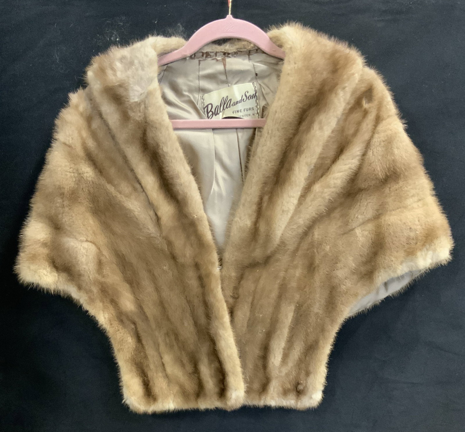 Balla and Son mink shawl: Balla and Son mink shawl. Initial patches of APA sewn into the lining of the right side. Hook closure. Lining has rips by the neckline and one rip at the bottom. Some matted fur on upper back. Mink, s
