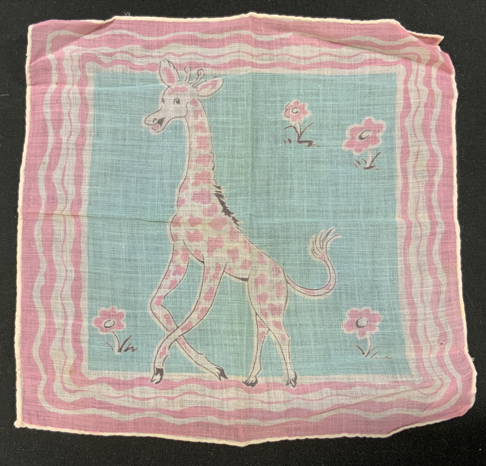 Vtg 1950s Novelty Giraffe Childrens Handkerchief: Vintage 1950s Novelty Giraffe Childrens Handkerchief. Pink spotted giraffe stepping through a field with flowers. Pastel color palette. Lightweight lawn cotton. Condition consistent with exposure Meas