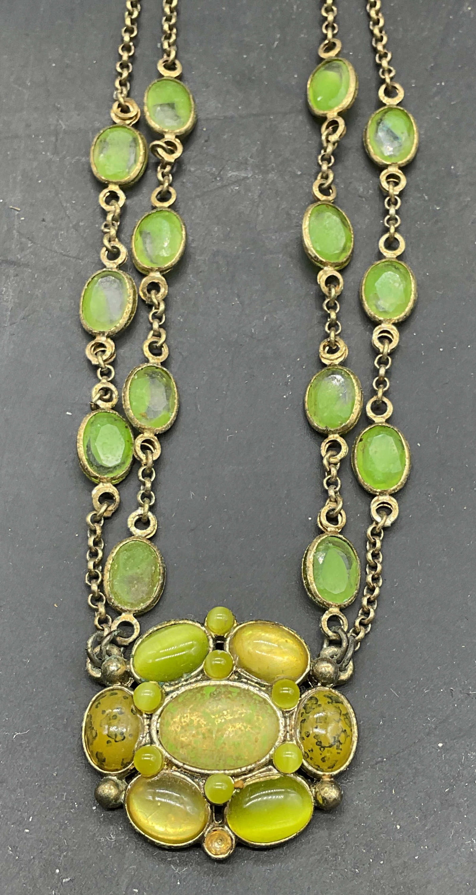 LC Gold Tone Green Crystal Necklace: Signed LC gold tone pendant necklace with green crystals. Drop length measures approx. 8.25 inches. Some crystals need replacement. Some scratching. Jewelry, estate jewelry, costume jewelry, cocktail 