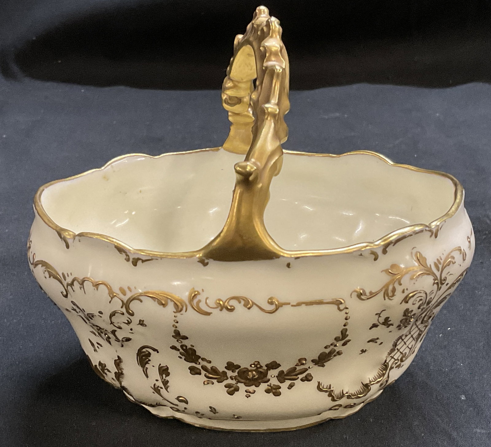 ANTQ CA Limoges Porc Bridal Basket FRANCE: Antique Circa 1894-1930 Charles Ahrenfeldt Limoges Bridal Basket. Cream Porcelain Body with Hand-Painted Gilt Floral Patterns and Grapevine Design Handle. Crack in Handle and Paint Losses. Measures
