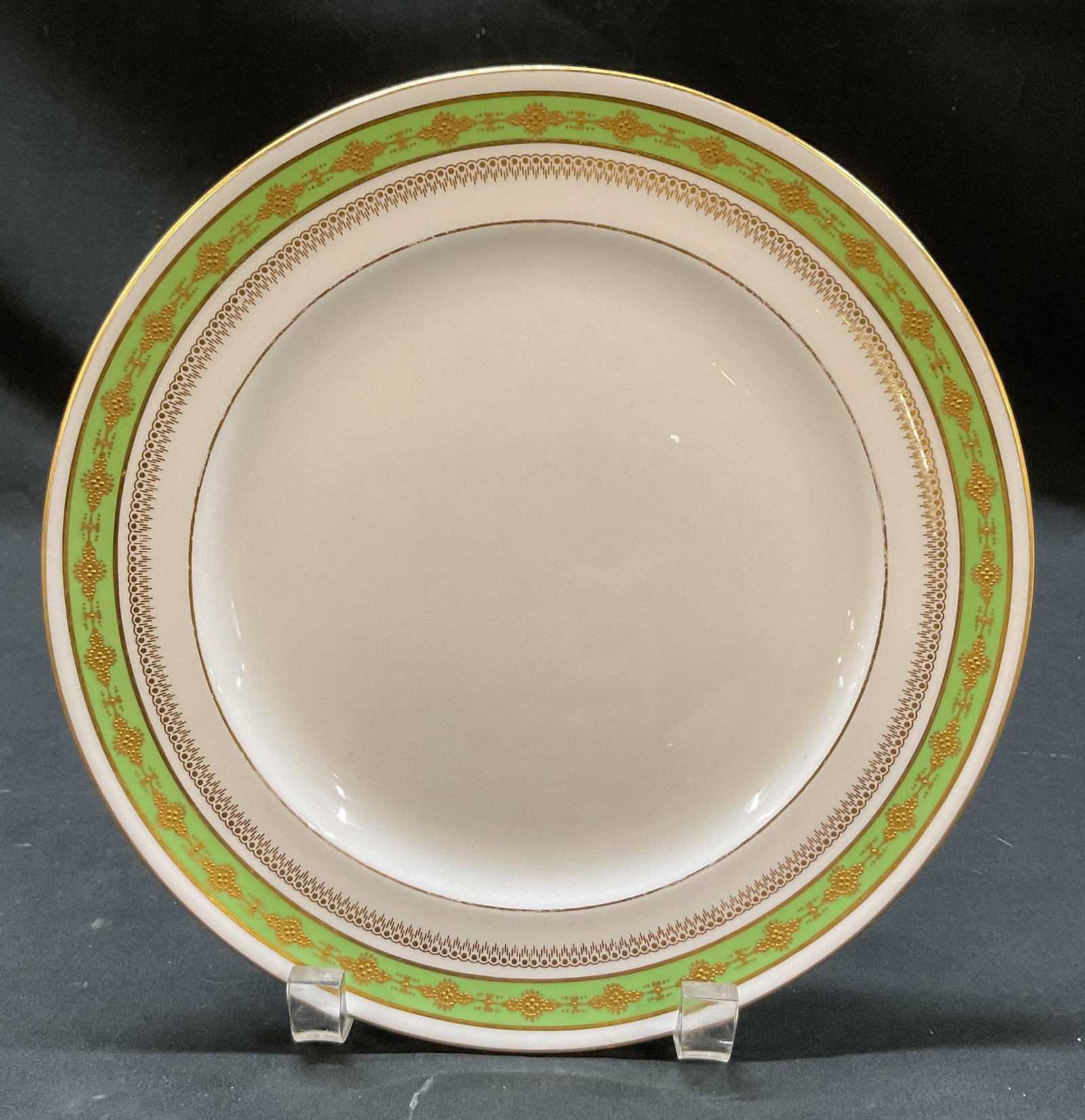 Royal Crown Derby Porcelain Green Plate England: Royal Crown Derby porcelain green plate. Marked on underside, reads Royal Crown Derby England Tiffany & Co New York. Round plate with gilt rim. Green and gilt design. Embossed floral and scroll motifs