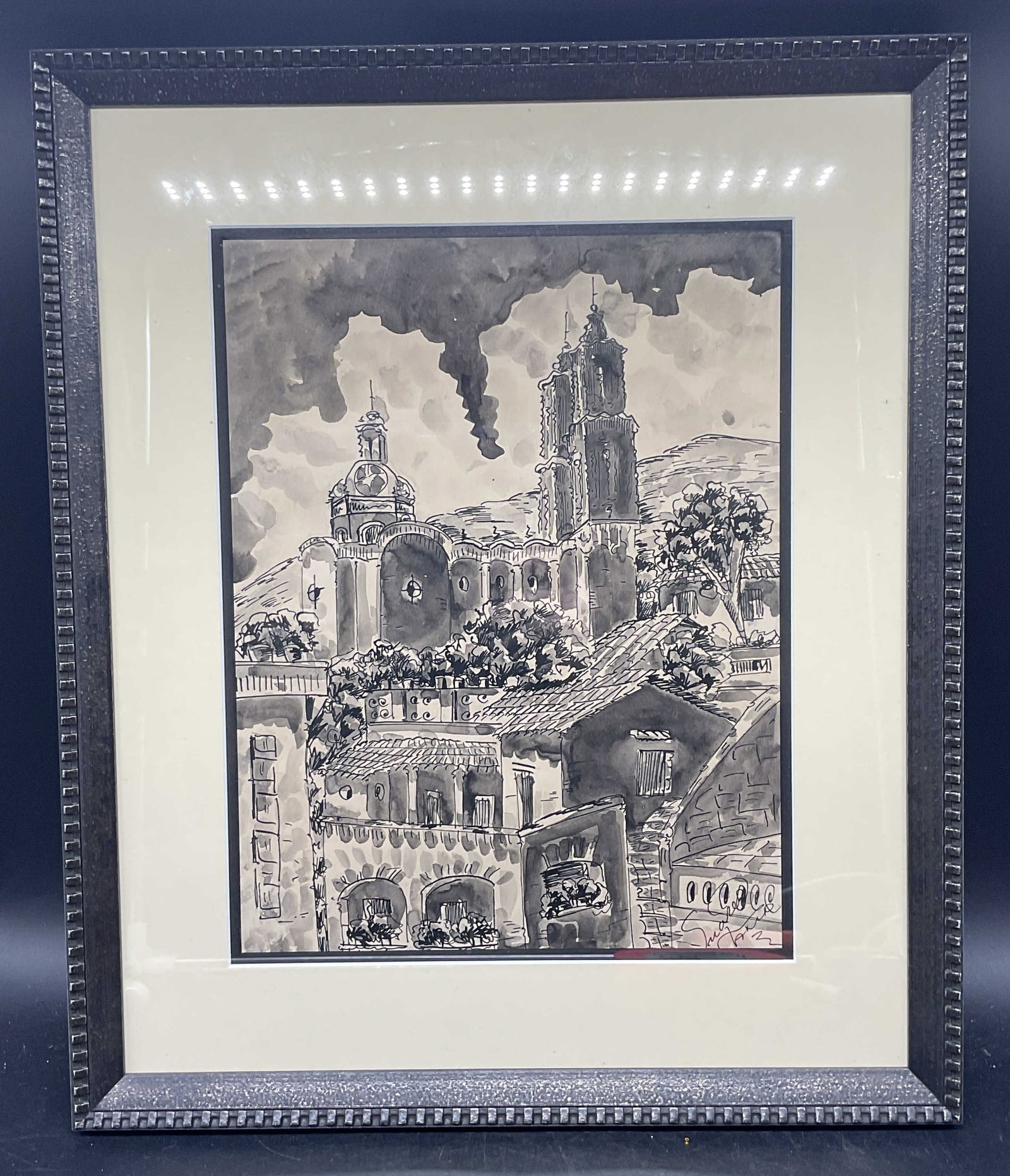 Signed Suarez Mexican Cityscape Ink Painting: Framed and matted ink painting. Signed lower right, Suarez, Taxco. Mexican scene with view of city. Black wood frame. Not examined out of frame. Frame measures approx. 18.5 x 15.5 inches. Some wear co