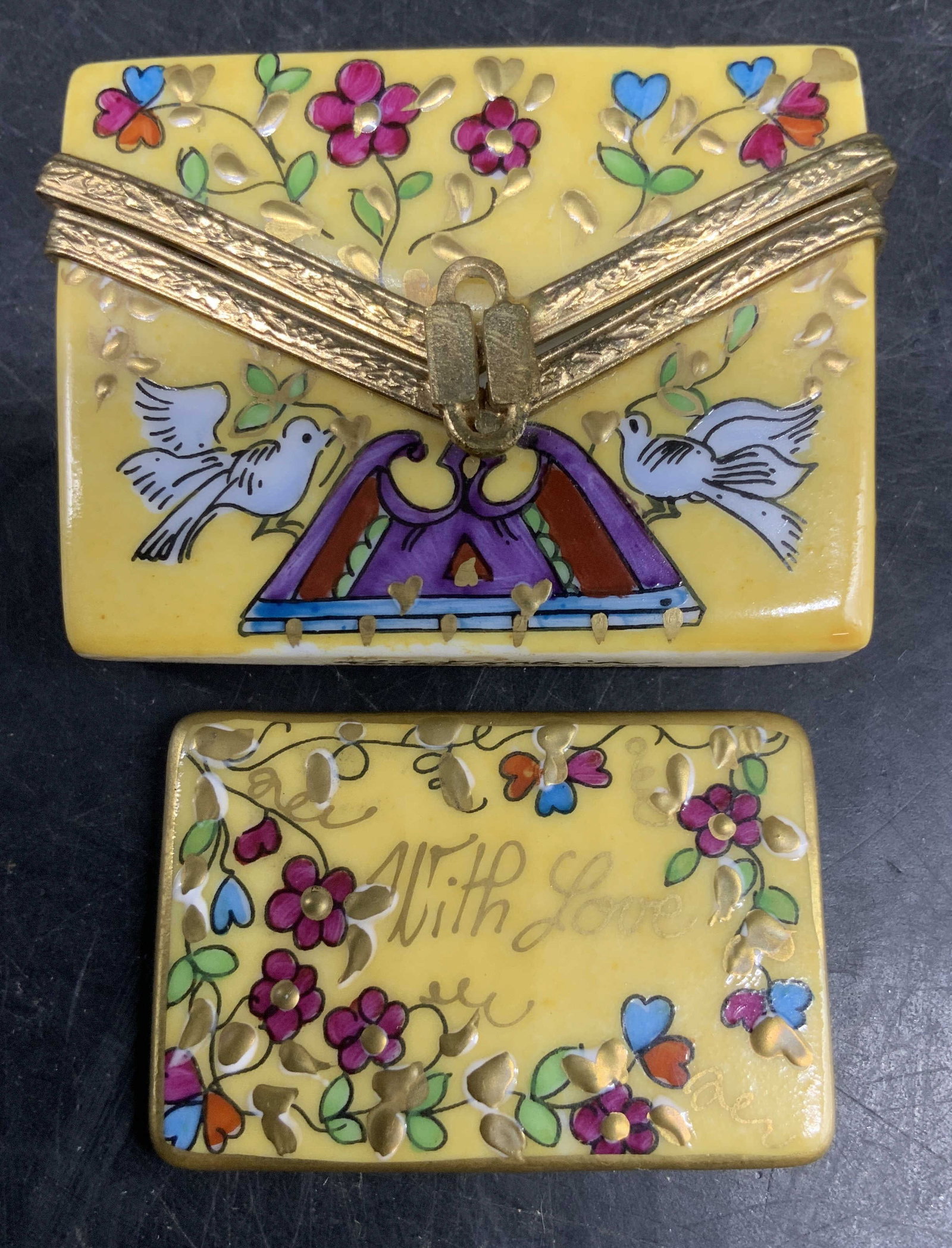 Limoges France Pill Box w Mirror insert: Hand painted Signed Limoges porcelain trinket box shaped like a yellow envelope, featuring a floral design with two love birds, the clasp is a gold toned figure 8 clip, and gold toned metal trim to en
