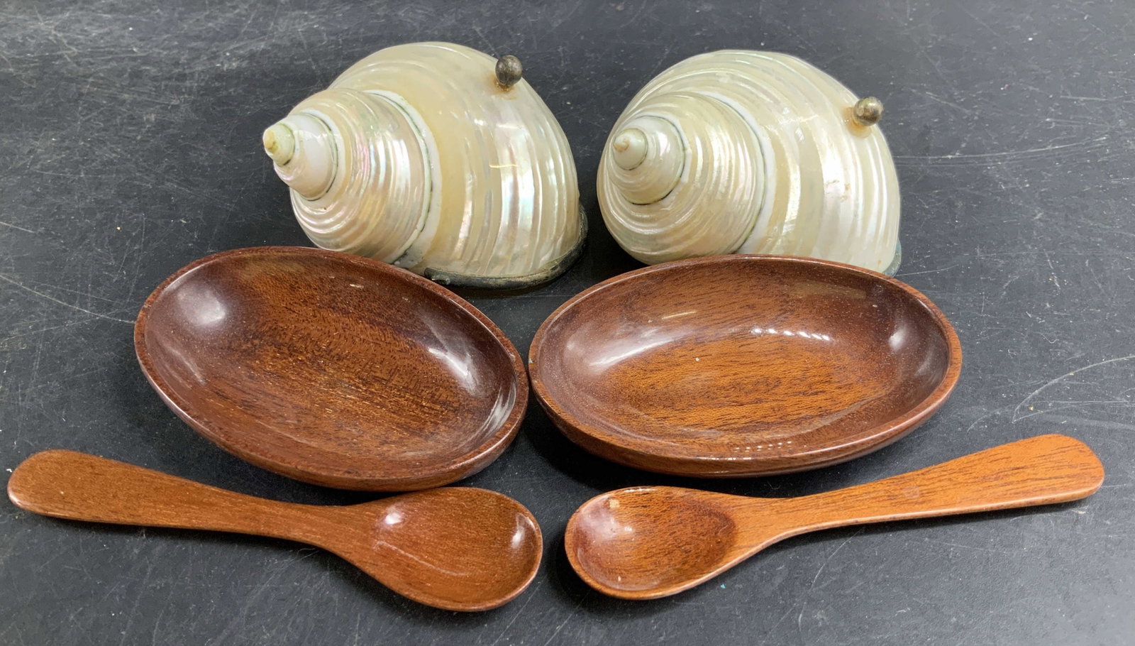Pr Nautilus Shell Dish Spoon Sets w Box: Pair of Silver trimmed pearlescent Nautilus shells that fit over glossy wood oval dishes with matching glossy wood short spoons, comes in fitted box marked for Cartier, each pearlescent nautilus shell