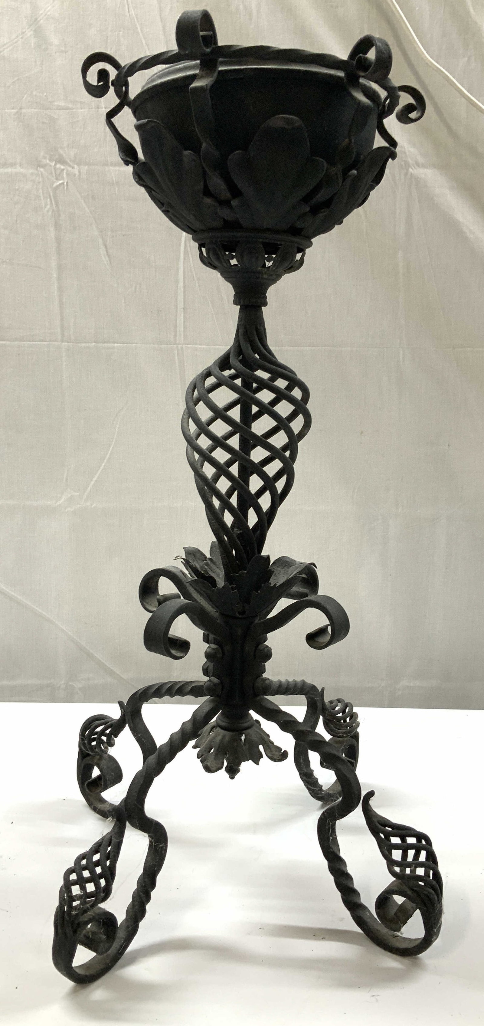Ornate Wrought Iron Plant Stand 26 inches: Ornate Wrought Iron Plant stand features a scrolling four foot base a cage like central column and a leaf form scrolled top with inner bowl, measures ht 26 inches diameter app 16 inches diagonal ,