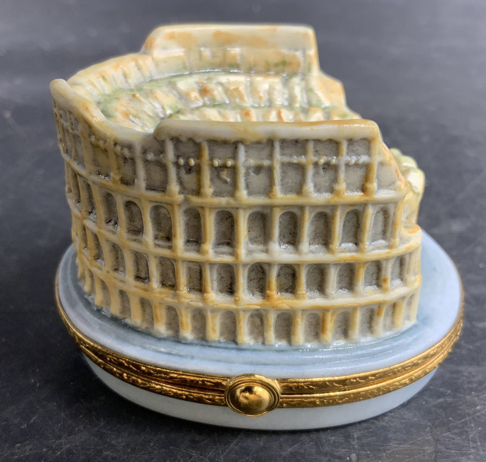 Limoges Roman Coliseum Porcelain Pill Box: Porcelain pill box hinged lid, featuring the Roman Coliseum underside reads Artoria Limoges made in France, measures ht app 2 inches, base app 3 by 2.5 inches, s