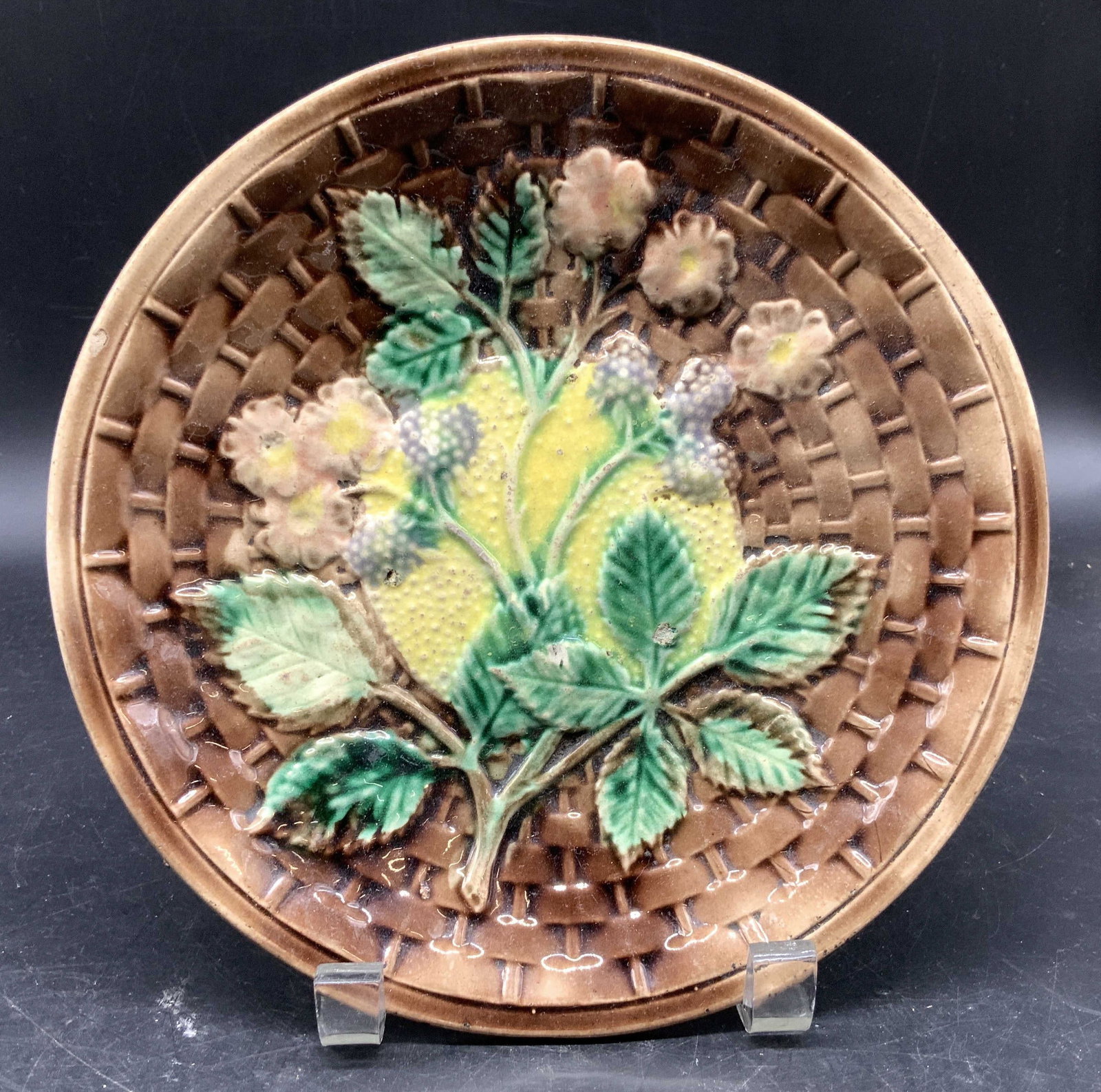 Antique English Majolica Plate berries Floral: Antique English Majolica Plate from 19th century featuring a brown textured basket weave design , with a centerpiece of a vibrant motif of berries, flowers and foliage app 8 inch diameter , property o