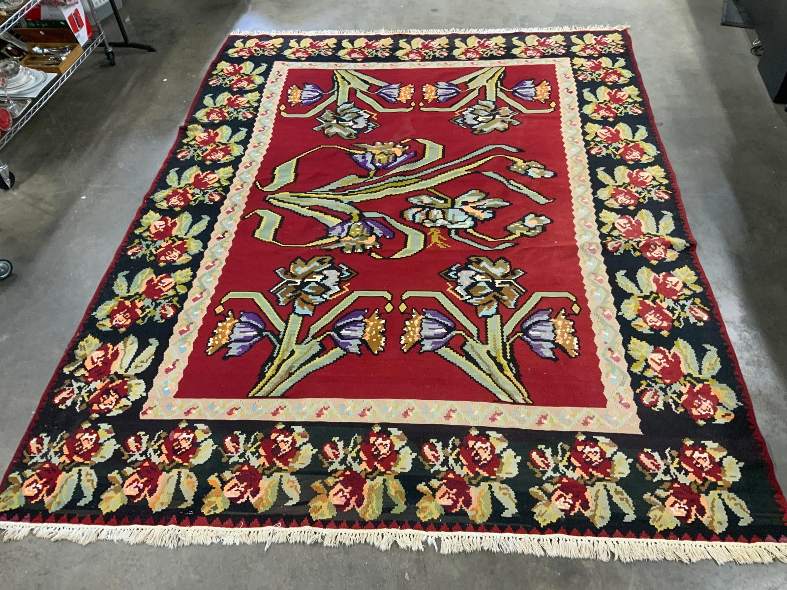 Vntg Hand Woven Bessarabian Kilim Rug: Vintage hand woven Bessarabian Kilim wool rug features a vibrant red field background adorned with large scale geometric floral motifs and a contrasting wide dark border, hand woven from wool, this fl