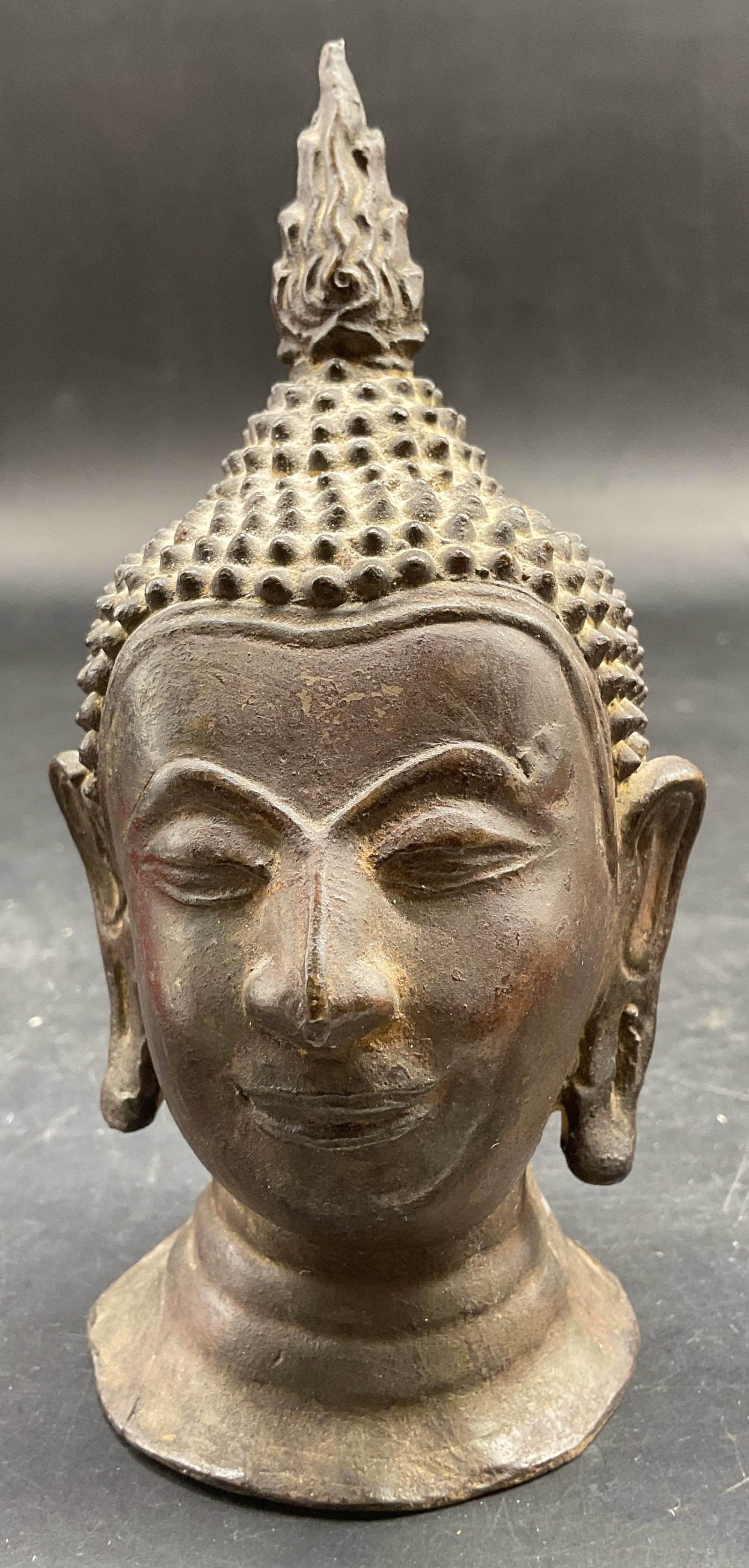 Bronze Buddha Head Figural w Ushnisha: Vntg bronze Buddha head figural w elongated earlobes and serene expression and a flame like Ushnisha atop the head, decorative object measures ht app5inches by 3 inches by 3 inches