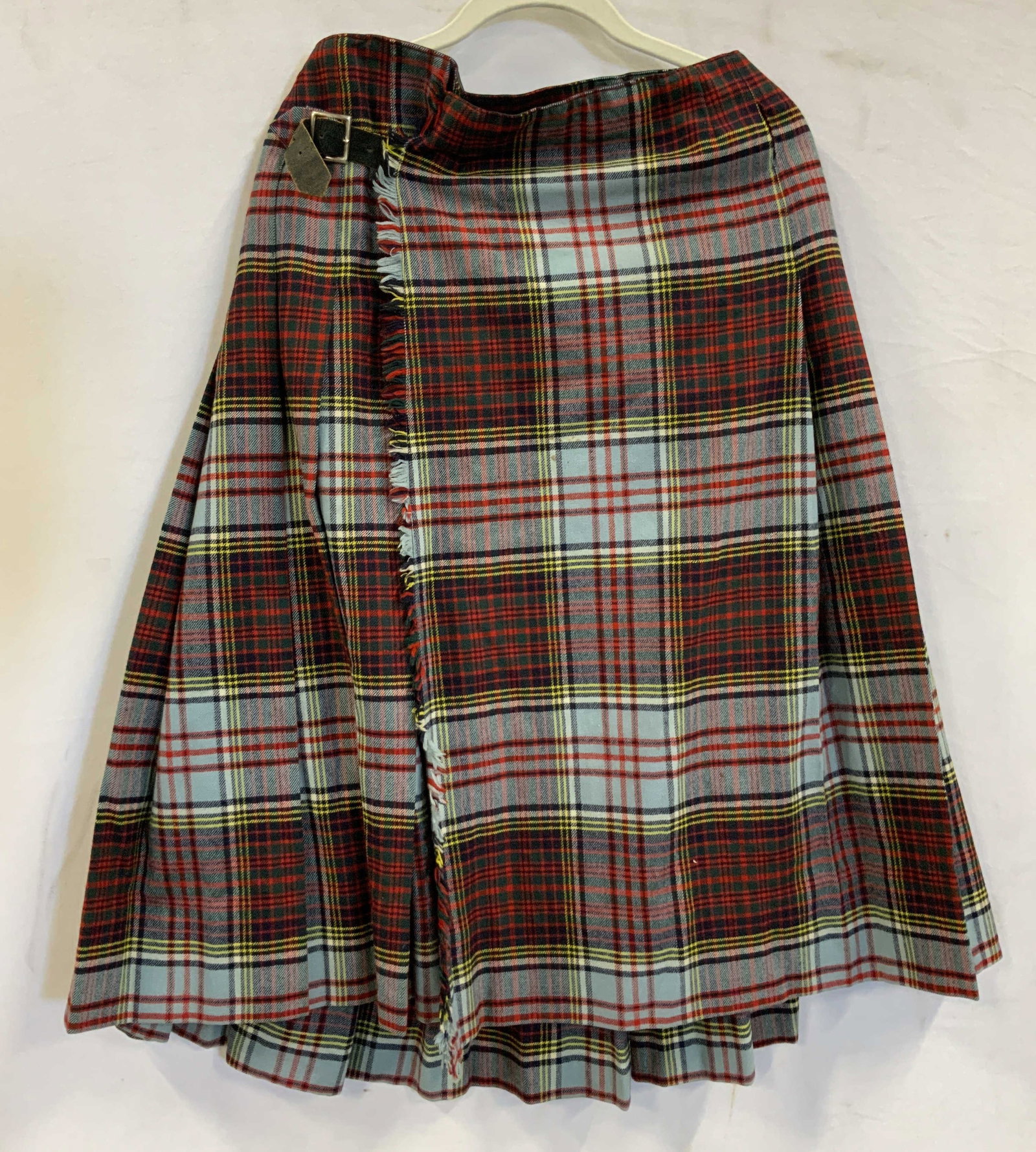 Plaid kilt skirt wool: Plaid kilt skirt made of wool. Skirt features 2 buckles on the sides left buckle is missing the strap from the inside. Outside flap goes from left to right. Snap closure across the top. No size, measu