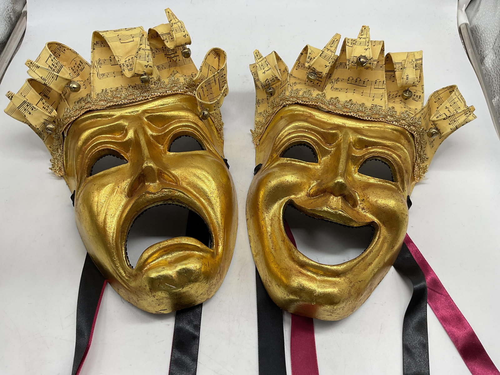 Gilt Pr Katherines Papier Mache Venetian Masks: Bright gold and silk ribbon pair of comedy tragedy Theatrical Venetian Madks by Katherines Collection, gold leaf finishes, musical note paper accents, brass bells, felt lined backs and cascading silk