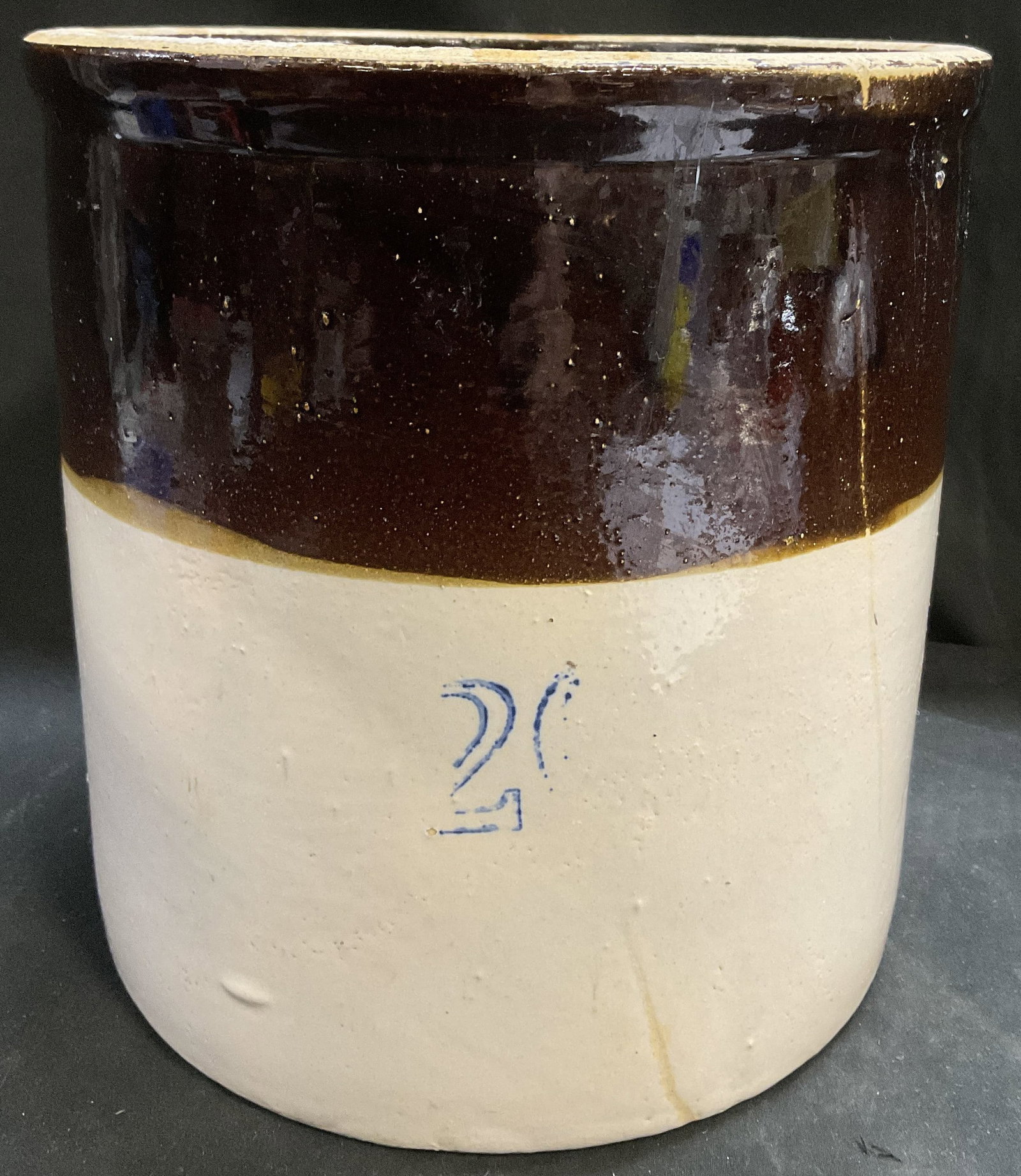 ANTQ Two-Tone Stoneware Utility Crock: Antique Two-Tone Glazed Stoneware Utility Crock. Dark Brown and Beige. Faded Hand-Painted Numbers, Likely Referring to 2 Gallon Capacity. Scraping and Chips Present. Measures app 9.5in H x 9in Diam. A