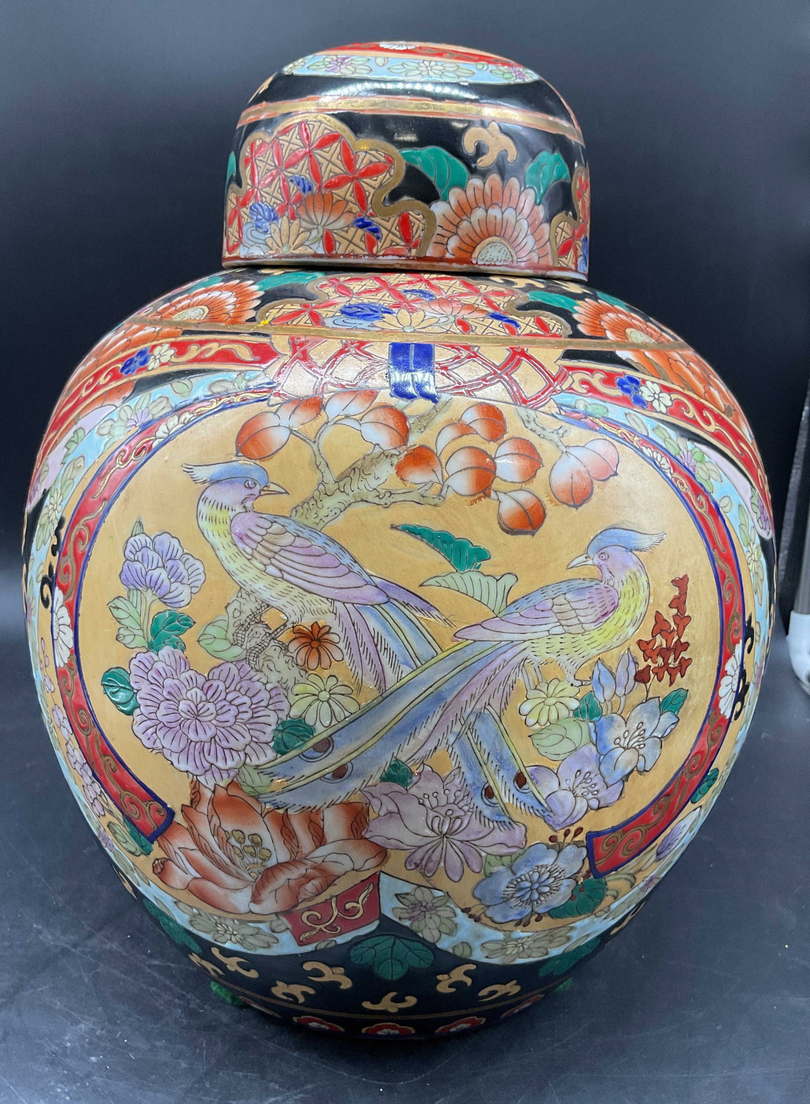 Chinoiserie Colorful Bird Floral Ginger Jar: Lidded ginger jar with ornate colorful design featuring birds, florals, geometrics in colors of crimson, reds, blues and yellows and pinks, labels on underside, measures ht app 13 inches, diameter