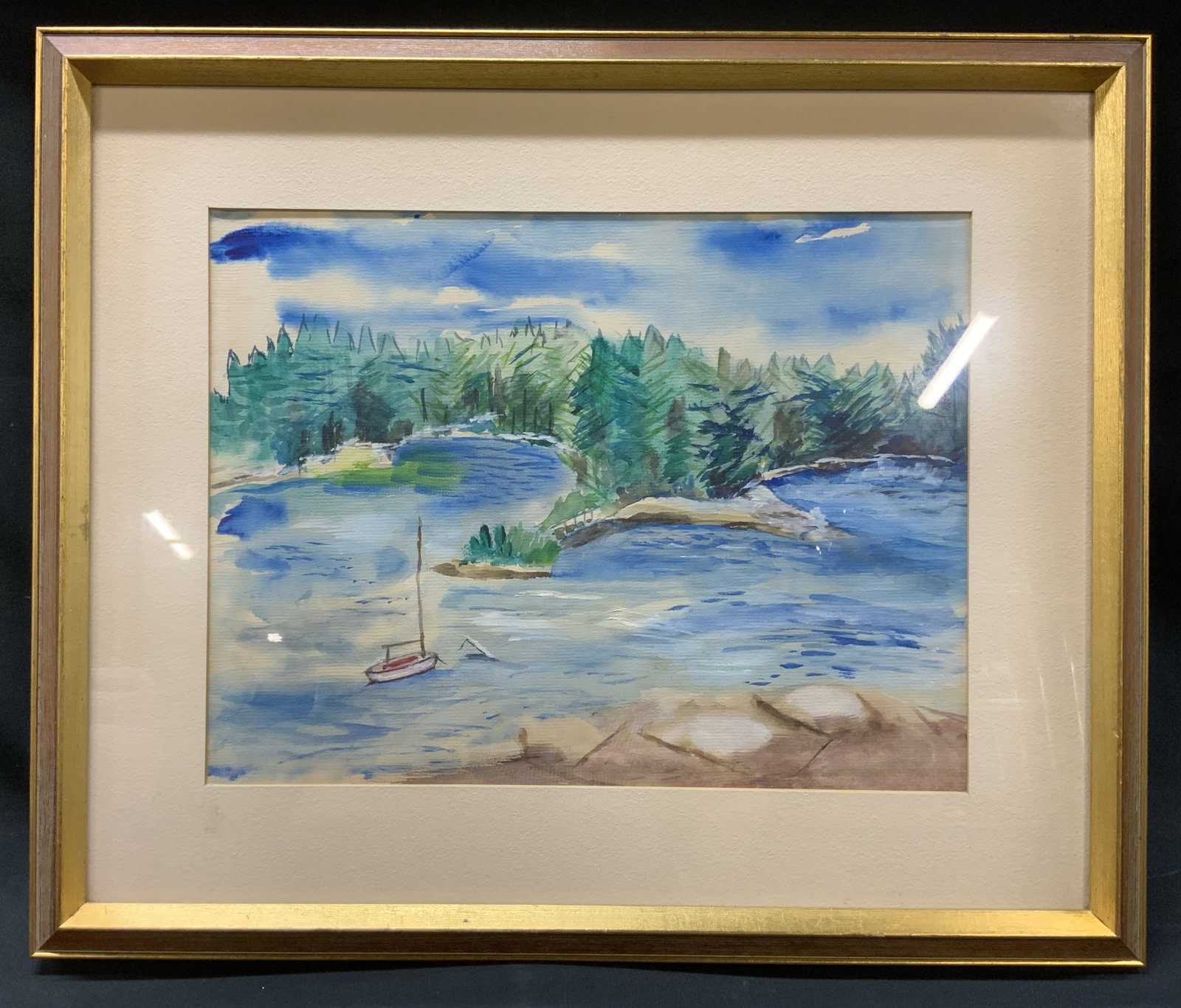 Vtg Watercolor Water Landscape Painting: Vintage framed and matted watercolor water/lake still life painting. Depicts a scene of a body of water with a small boat, trees/woods made up of various shades of green, abstracted organic forms