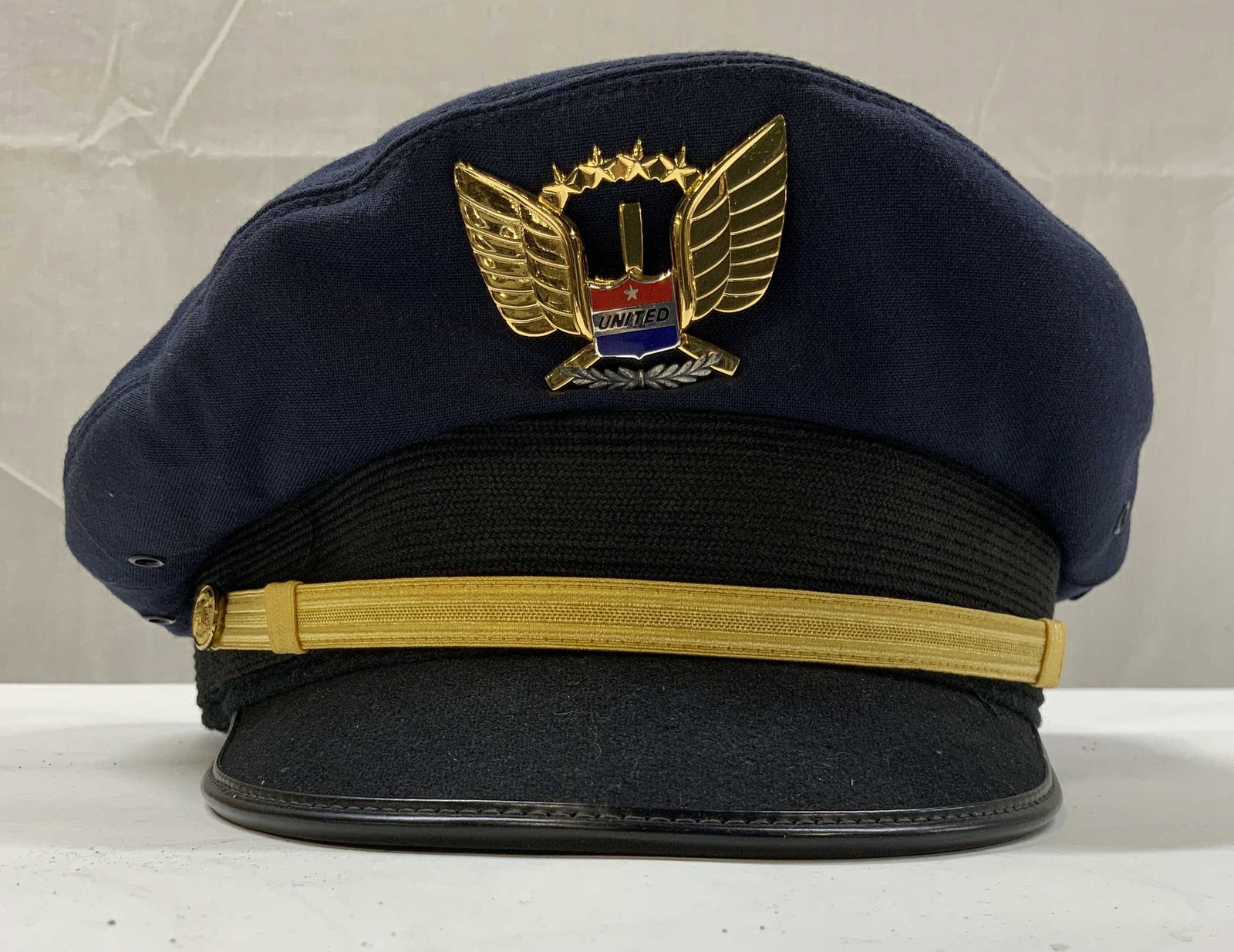 Vntg United Airlines Pilots Captain Hat: Vintage United Airlines pilots captain hat. Features dark blue fabric with gold colored winged crest pin featuring the untied emblem and gold trim. Made by superior uniform cap co. Measures app 6 in h