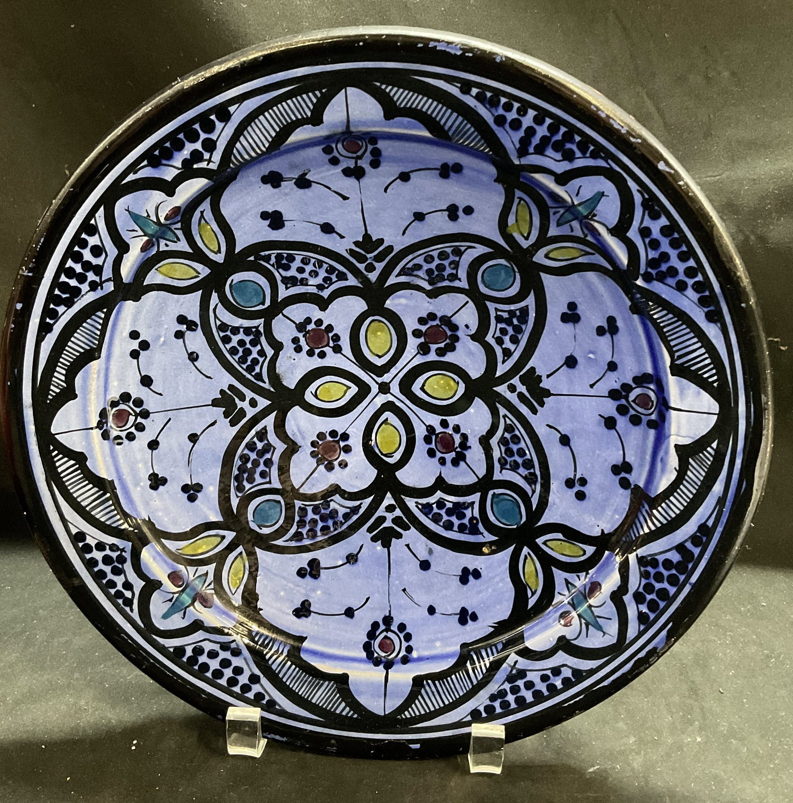 Hand-Painted Moroccan Pottery Bowl: Hand-Painted Moroccan Pottery Bowl. Geometric Design with Black Fine-Line Filigree Filled with Green and Blue Accents. Vibrant Periwinkle Background. Hanging Rope on Back. Some Paint Loss. Measures ap