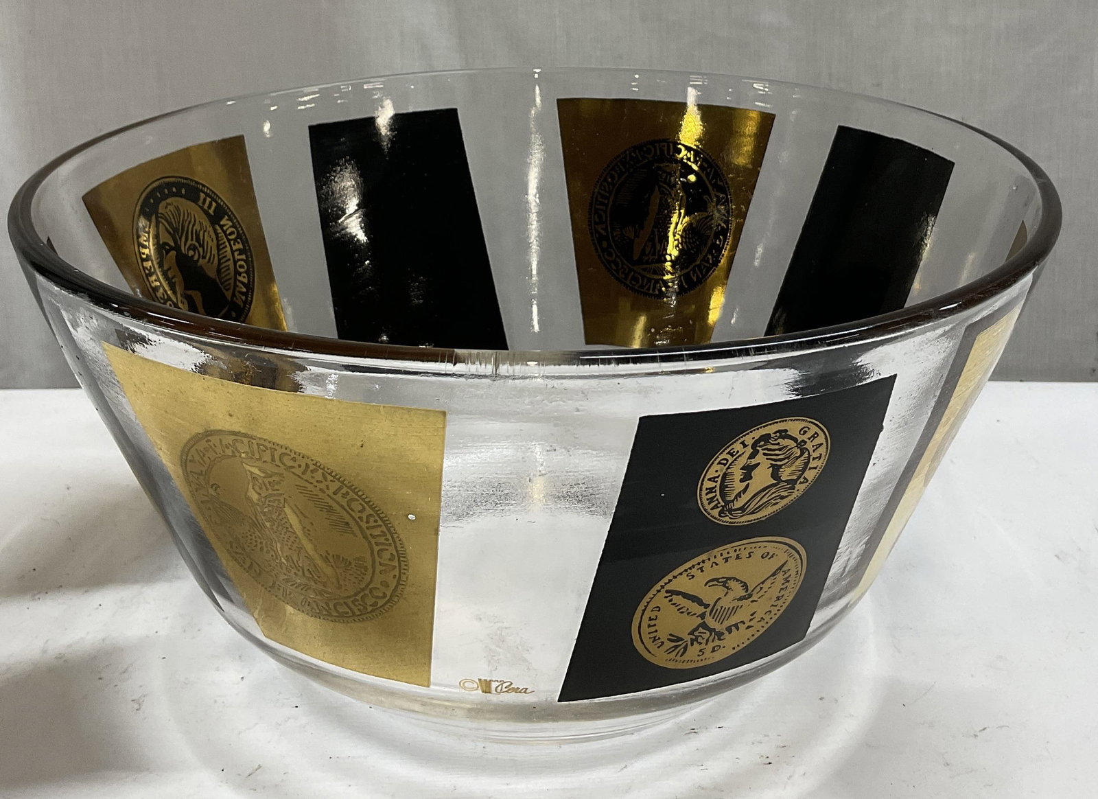 MCM Cera Glass 22K Gold Coin Motif Bowl: Mid-Century Modern Circa 1950s-1970s Cera Glass Bowl. 22K Gold Screen-Printed Panels Featuring Various Coins on Black and Gilt Backgrounds. Condition Consistent With Exposure. Measures app 5in H x 10i
