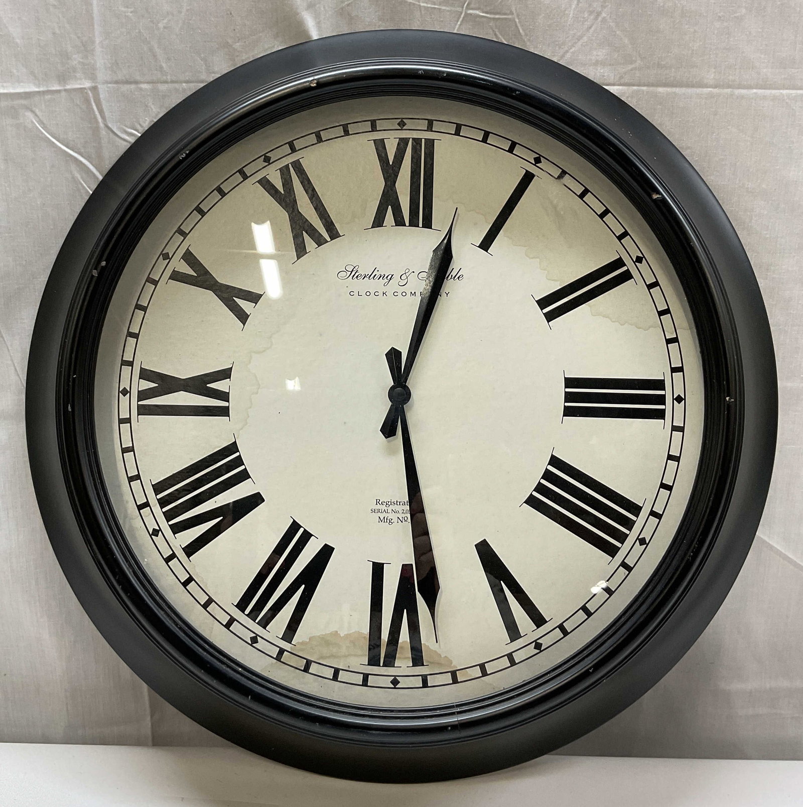 Sterling & Noble Oversize Black Wall Clock: Sterling & Noble oversize black wall clock. Black wooden frame. Roman numerals. Marked on surface as photographed here. Measures approx 23 inches in diameter. Not tested for function, sold as is. Wear