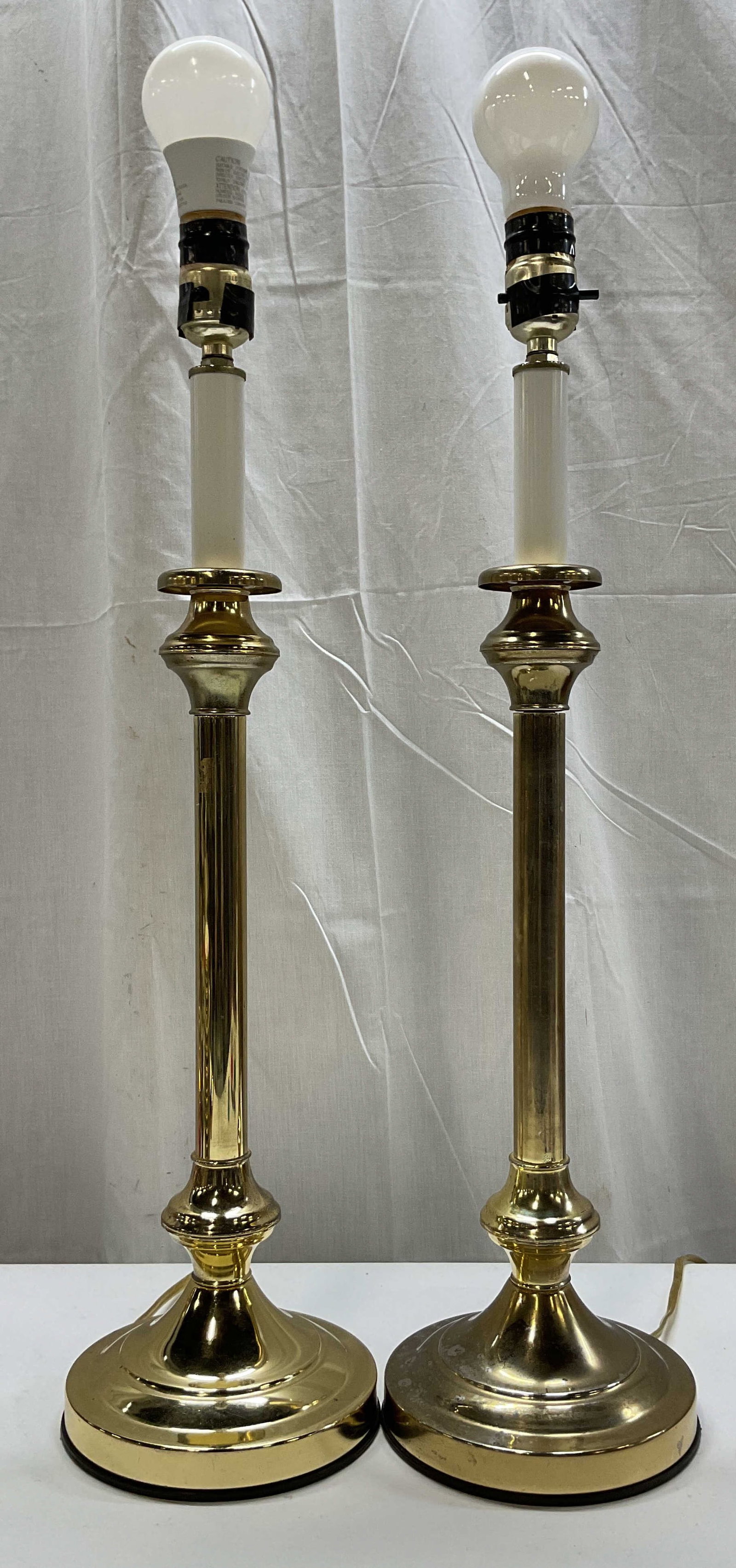 Pair Vintage Brass Toned Boudoir Table Lamps: Pair of vintage brass toned Boudoir table lamps. Candlestick design. Fluted column. Round stepped base. Measures ht approx 25.5 inches base diam approx 6.5 inches. Not tested for function, sold as is.