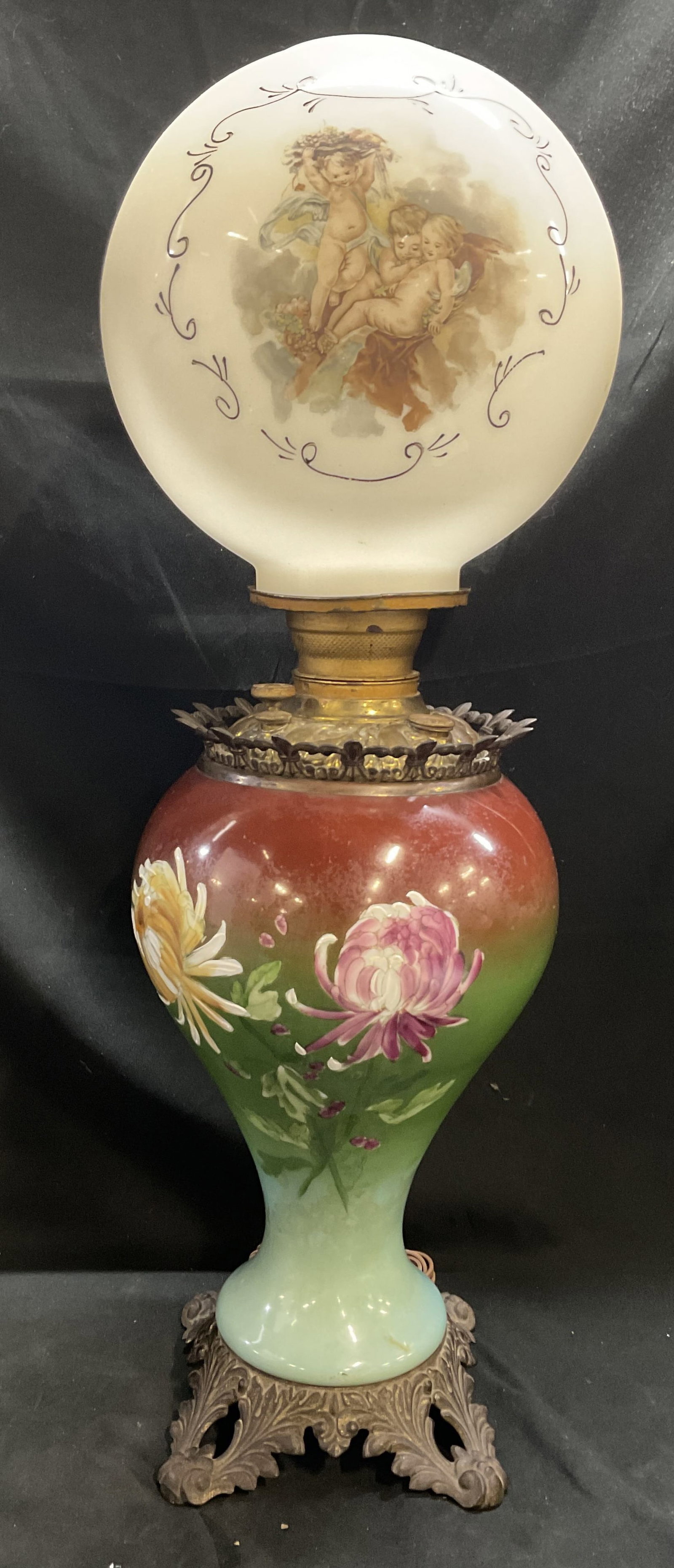 ANTQ Victorian Gone with the Wind Parlor Lamp: Antique Victorian Gone with the Wind Parlor Lamp. Glass Body with Hand-Painted Floral Motifs on Gradient Background. Acanthus Leaf Design Brass Base. Milk Glass Globe Shade with Cherub Scene. Scratchi
