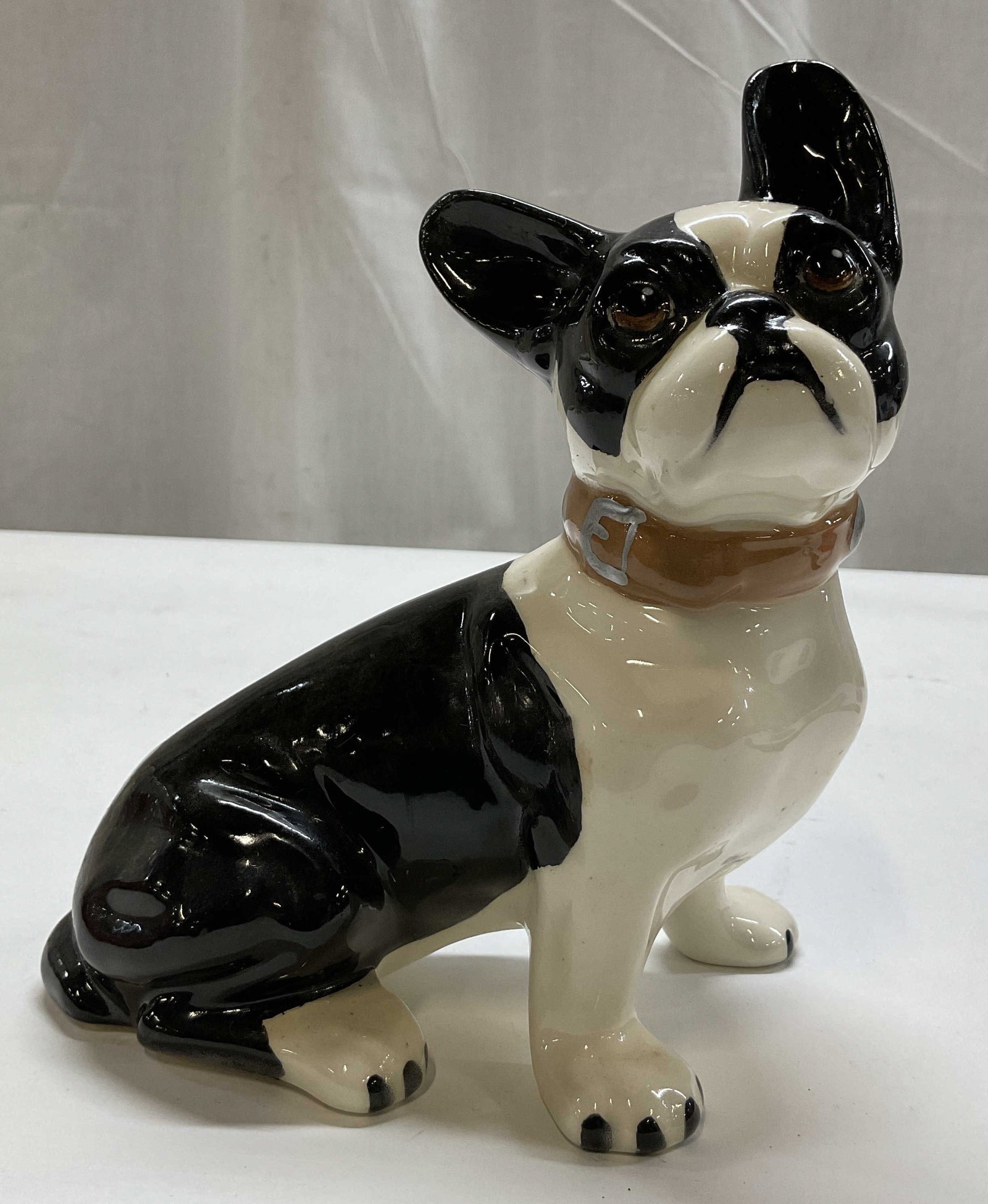 Vintage Black & White Ceramic Bulldog Figure: Vintage black and white ceramic bulldog figure. Signed on underside. Sitting bulldog figure. Tan collar with hand painted silver toned accents. Glossy finish. Measures approx 3.5 x 6 x 7.5 inches. Scr