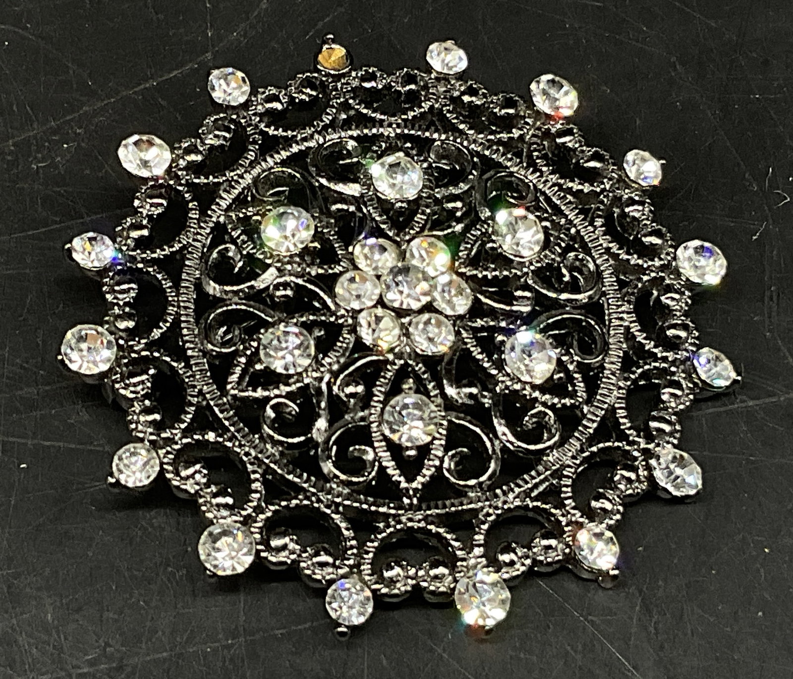 VTG Silver-Toned Openwork Filigree Mandala Brooch: Vintage Silver-Toned Openwork Filigree Mandala Brooch. Sparkling White Rhinestone Accents. Missing Stone. Measures app 1.75in Diam. Vintage Brooches, Pins, Silver-Toned, Filigree, Mandala, Rhinestones