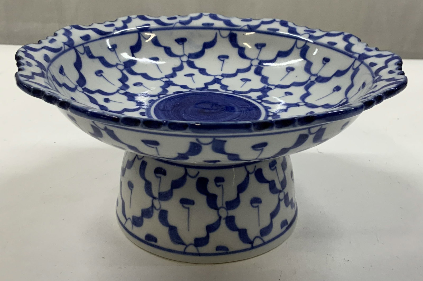 Thai ceramic pedestal plate , hand painted: Thai ceramic pedestal plate. Referred to as Pham tok in Thai culture. Featuring a hand painted blue and white pine pattern. It has a scalloped rim. Used for serving Thai curry, fruits or decorative ce
