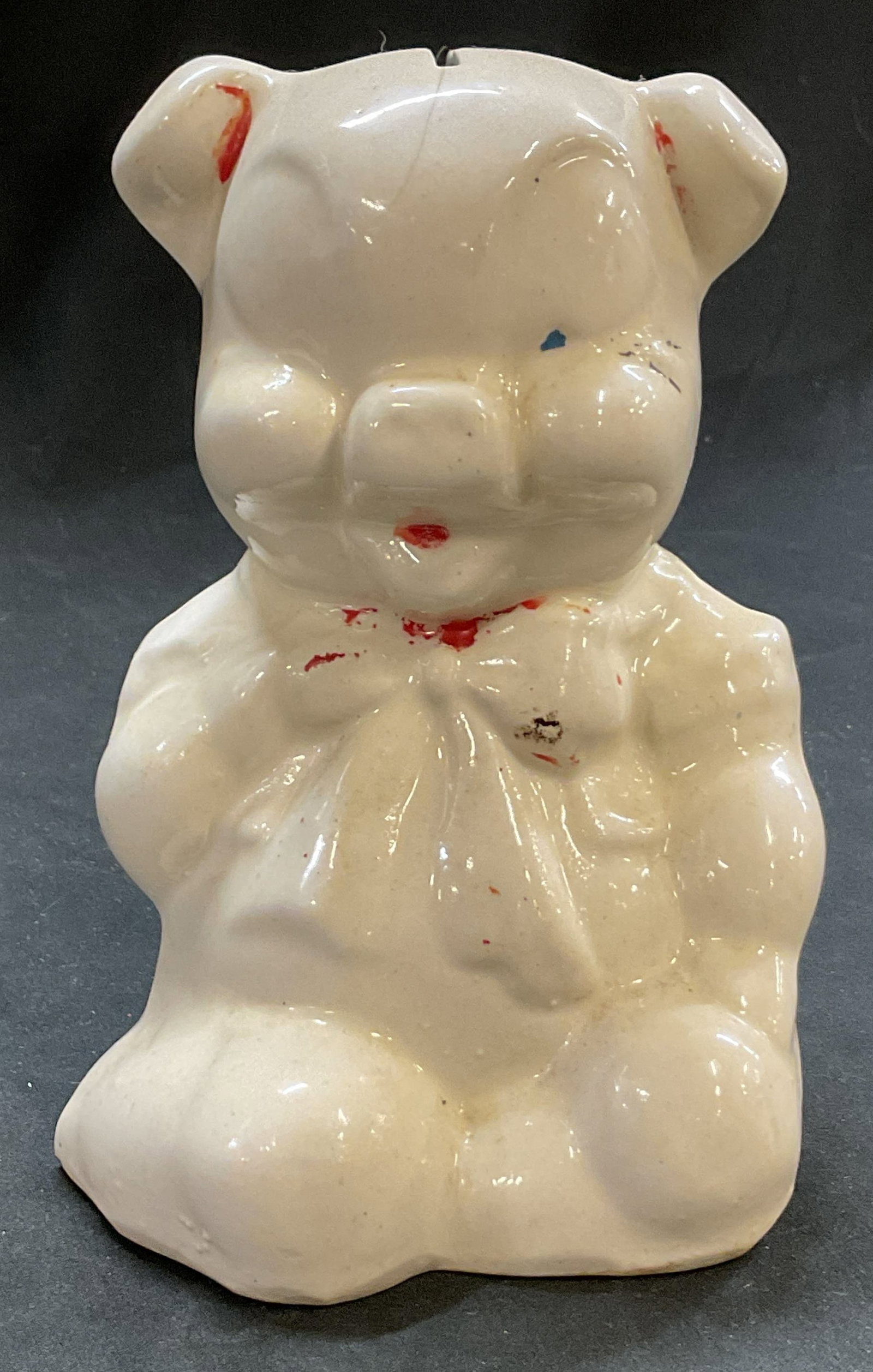 Shawnee Pottery Ceramic Pig Piggy Bank: Shawnee Pottery ceramic pig piggy bank. Glossy white glazed pig figure with sculpted bow tie. Coin slot on top of the head. Detailed features. Measures approx 4 x 5 x 6 inches. Wear and cracks, loss t