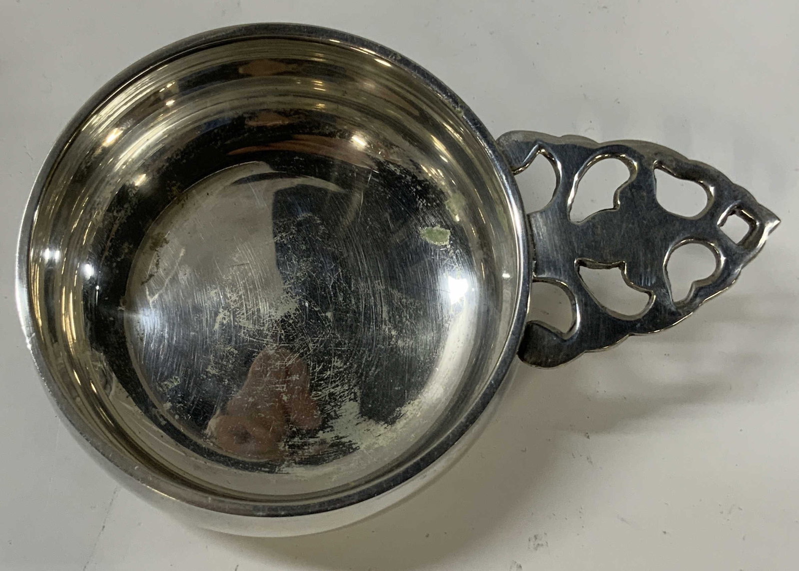 Vntg silver plated Porringer: Vntg silver plated Porringer. Porringer is a shallow bowl. Piece features a distinct ornate pierced and scrolled handle. Underside is stamped with silverplate, EPNS. Stands for electroplated Nicole si