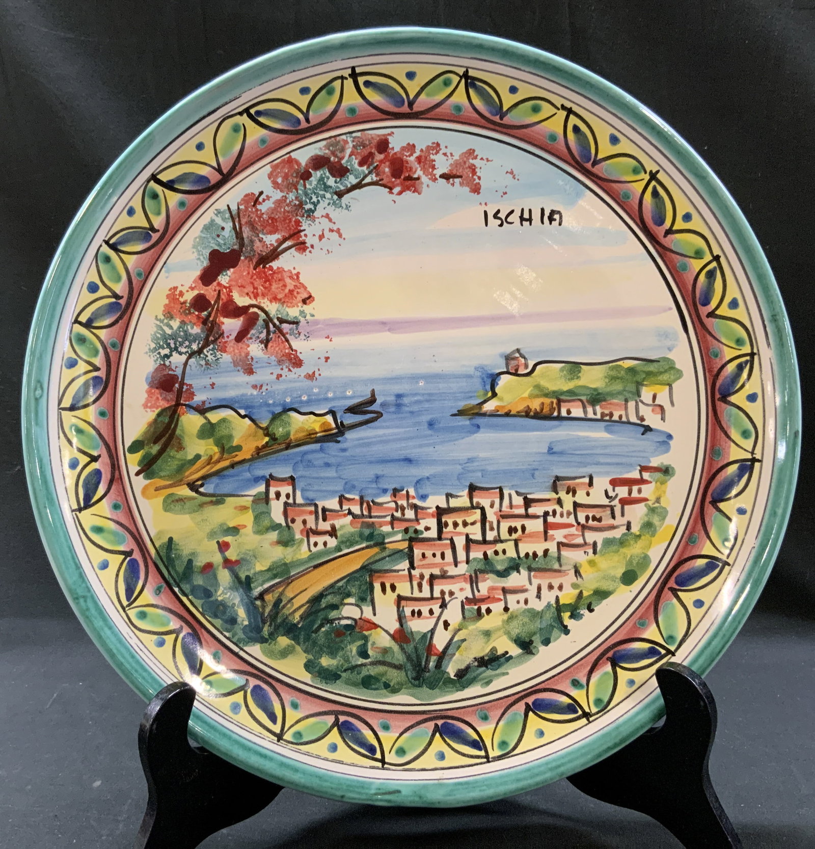 Vtg Italian Majolica Ischia Hanging Plate: Vintage Hand painted Italian Majolica Art Hanging Charger plate. Scenic coastal island of Ischia. Framed by teal green trim and repeating stylized leaf and circle garland. Measures approx. 12 in diame