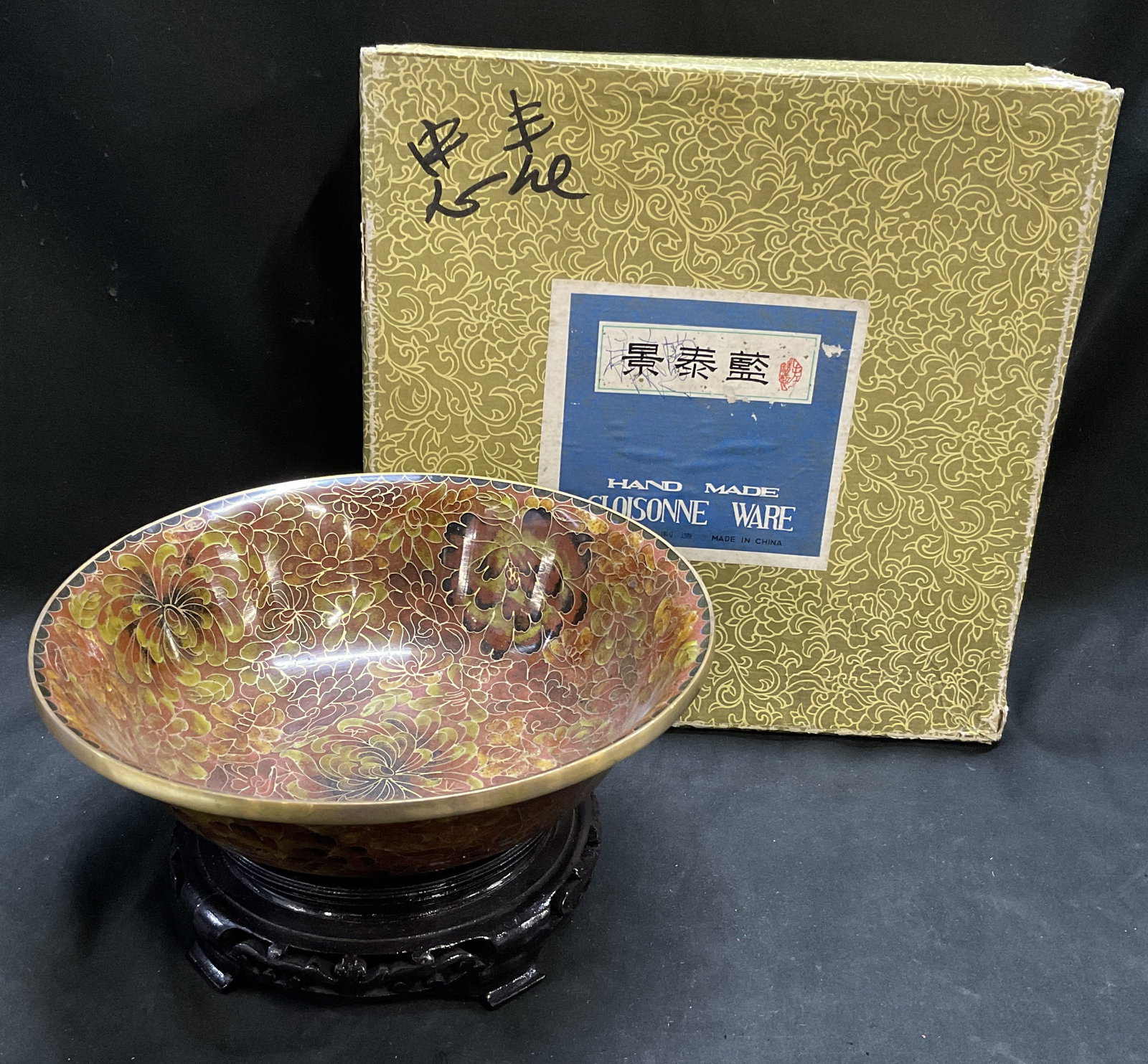 VTG CHINESE Zi Jin Cheng Cloisonne Bowl&Stand OB: Vintage Chinese Zi Jin Cheng Factory Cloisonne Bowl with Dark-Stained Carved Wooden Stand. Maroon and Green Floral Pattern Enamel Inlay on Brass. Comes in Original Box. Cracks and Chips on Stand. Tear