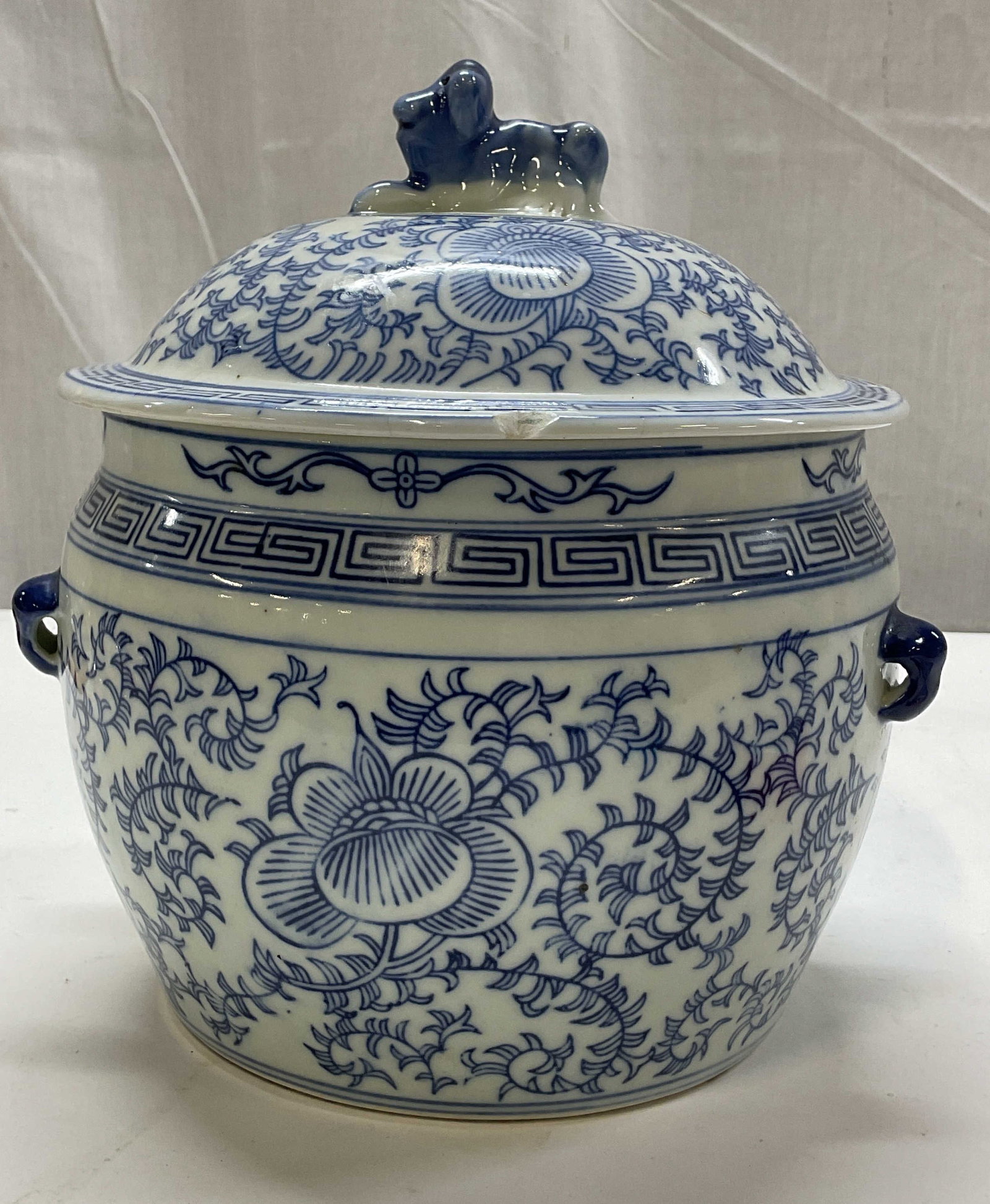 Vtg Chinese Blue & White Porc Lidded Ginger Jar: Vintage Chinese blue and white porcelain lidded ginger jar. Applied handle accents on either side. Blue and white floral and vine motifs. Greek key geometric borders. Sculpted Foo dog finial on lid. B