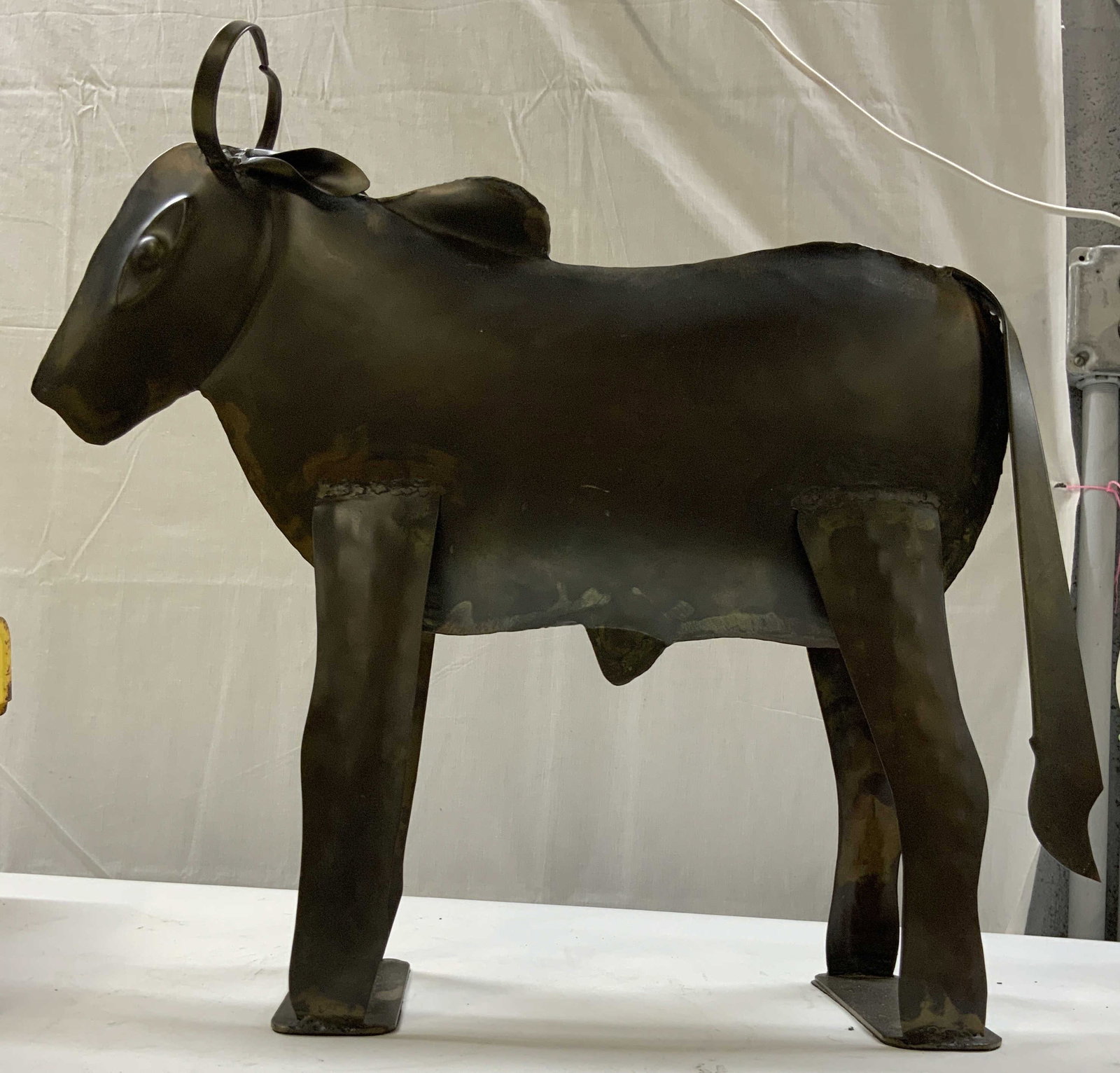 El Torro metal bull sculpture: El Torro metal bull sculpture. Dark binge finished welded metal bull. Features an abstract mid century brutalist design. Distinctive with a hamper back and flat plate legs. Constructed wheeled welded 