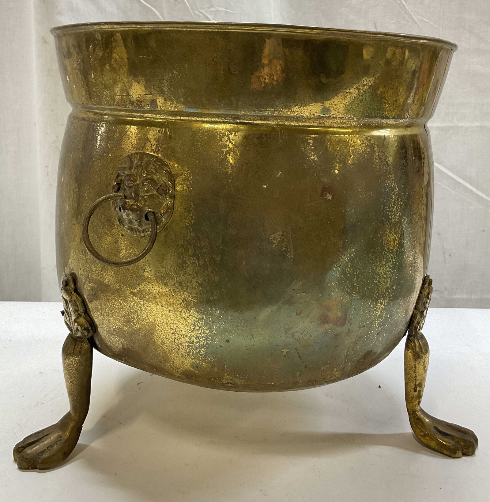 Vintage Brass Lion Paw Feet Jardiniere Planter: Vintage brass lion paw feet jardiniere planter. Round wide bulbous planter. Ornate tri paw feet with scroll motifs. Ribbed surface. Lion mask ring handles on either side. Measures ht approx 12 inches 