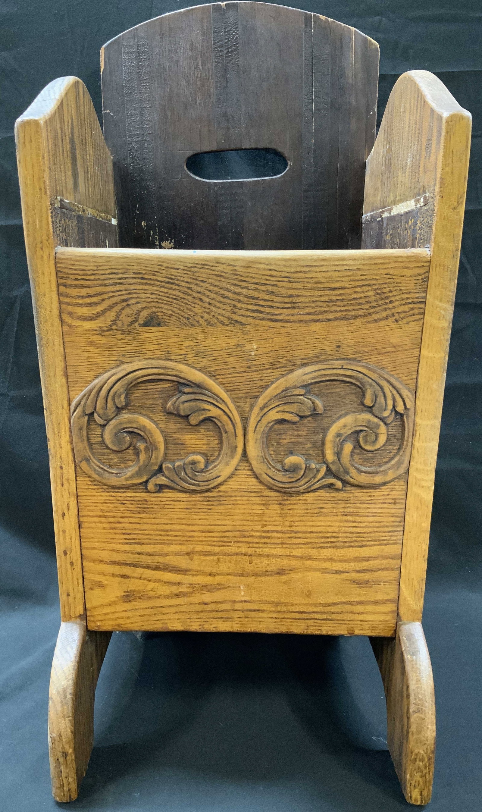 Vtg Carved Oak Magazine Rack: Vintage Carved Oak freestanding floor magazine rack. Two hand carved scrolling leaf medallions on front panel. Constructed with sloped side panels and high back splat with integrated horizontal cutout