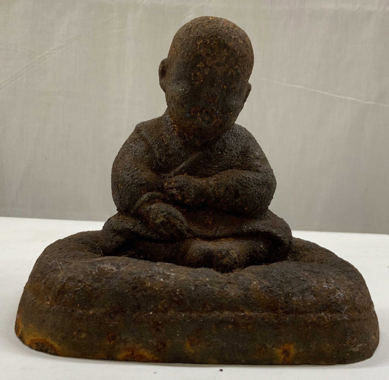 Vntg Metal figurine of seated monk: Vintage metal figurine of seated monk resting on a square base. Resembles an antique cast metal devotional sculpture. Heavily rusted and significant oxidation and wear. Measures app 6 in tall , app 6 