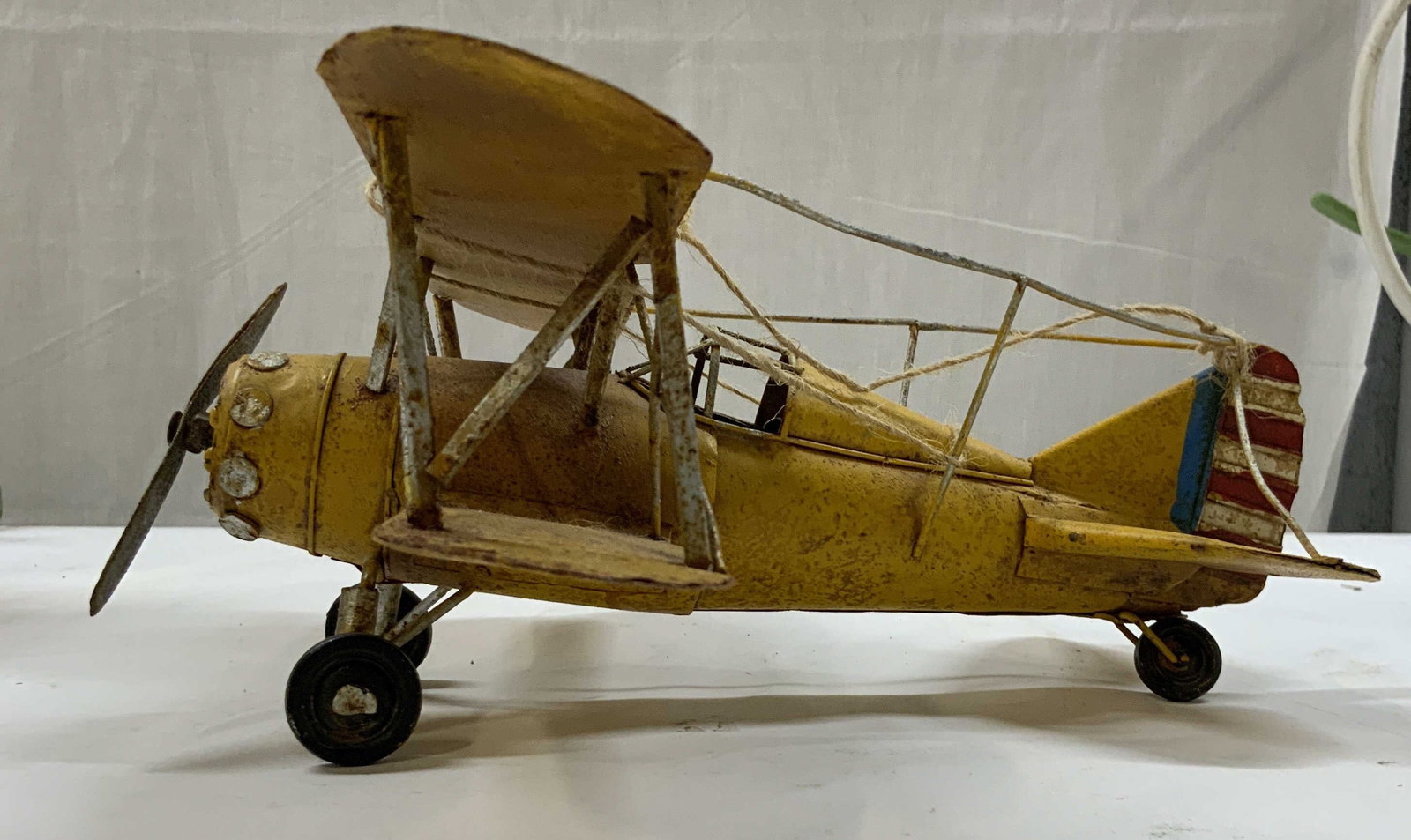 Vntg yellow metal biplane figurine.: Vntg yellow metal biplane figurine. Handcrafted piece designed as a retro tabletop accent or decor item. The upper wings prominently display historic military star insignia. The tail features red and 