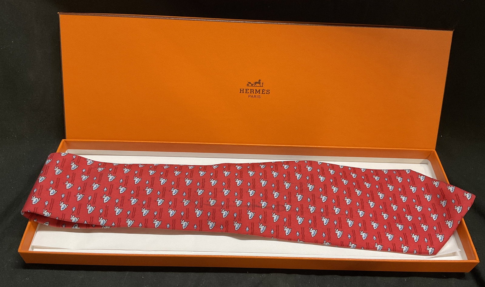OB Hermes 100% Silk Twill Duck & Fish Necktie: Hermes Paris 100% Silk Twill Necktie. Light Blue Pattern of Ducks Chasing Fish on Red Background. Original Box. France. Stain Present. Measures app 58in L x 3.5in W. Hermes, Paris, Silk, Necktie, Duck