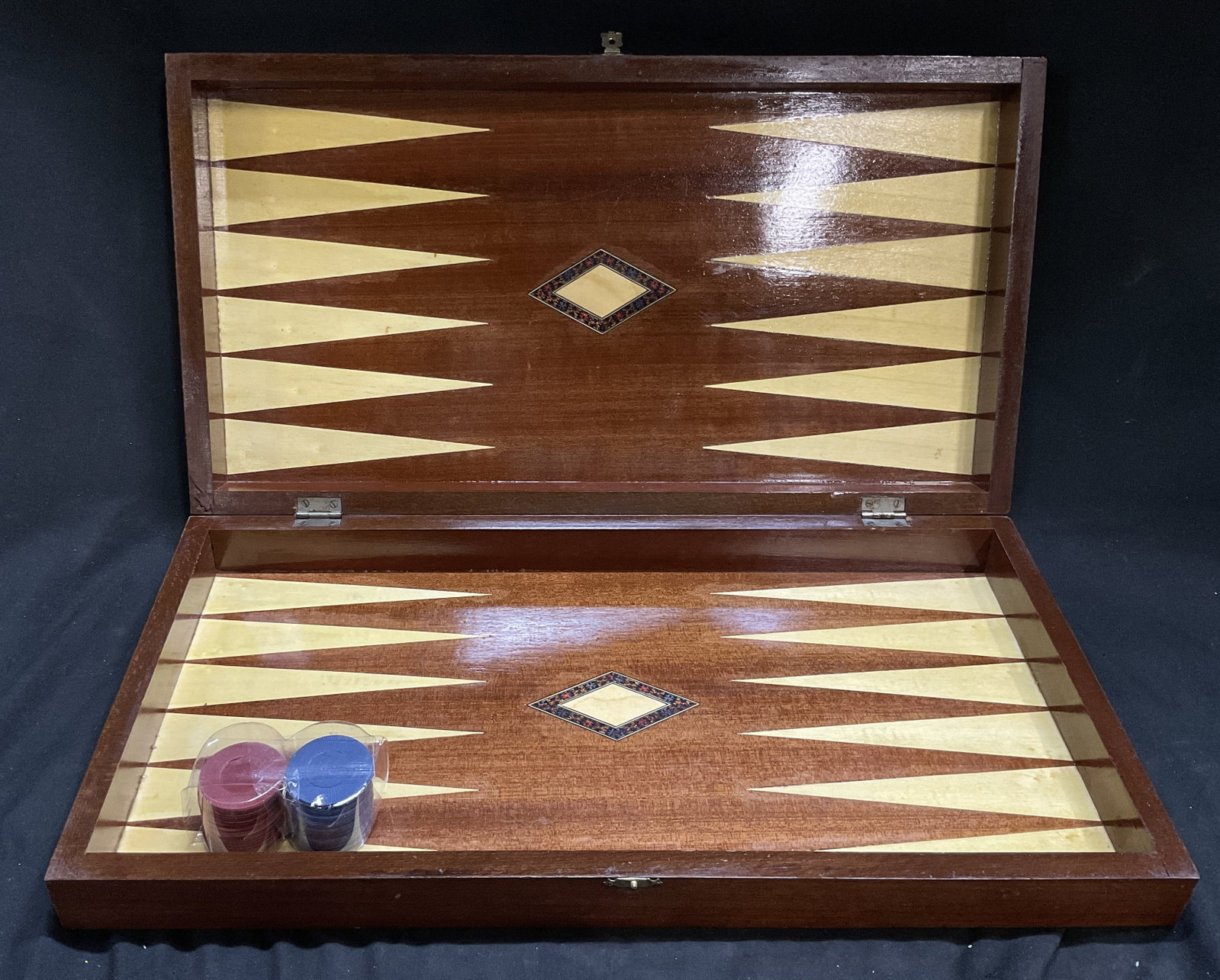 VTG Handcrafted Wooden Backgammon Board Case: Vintage Handcrafted Wooden Backgammon Board Case. Inlaid Light Wood Points. Dual Decorative Diamond-Shaped Marquetry Medallions in the Center Fields. Includes Red and Blue Playing Chips. Scratching an