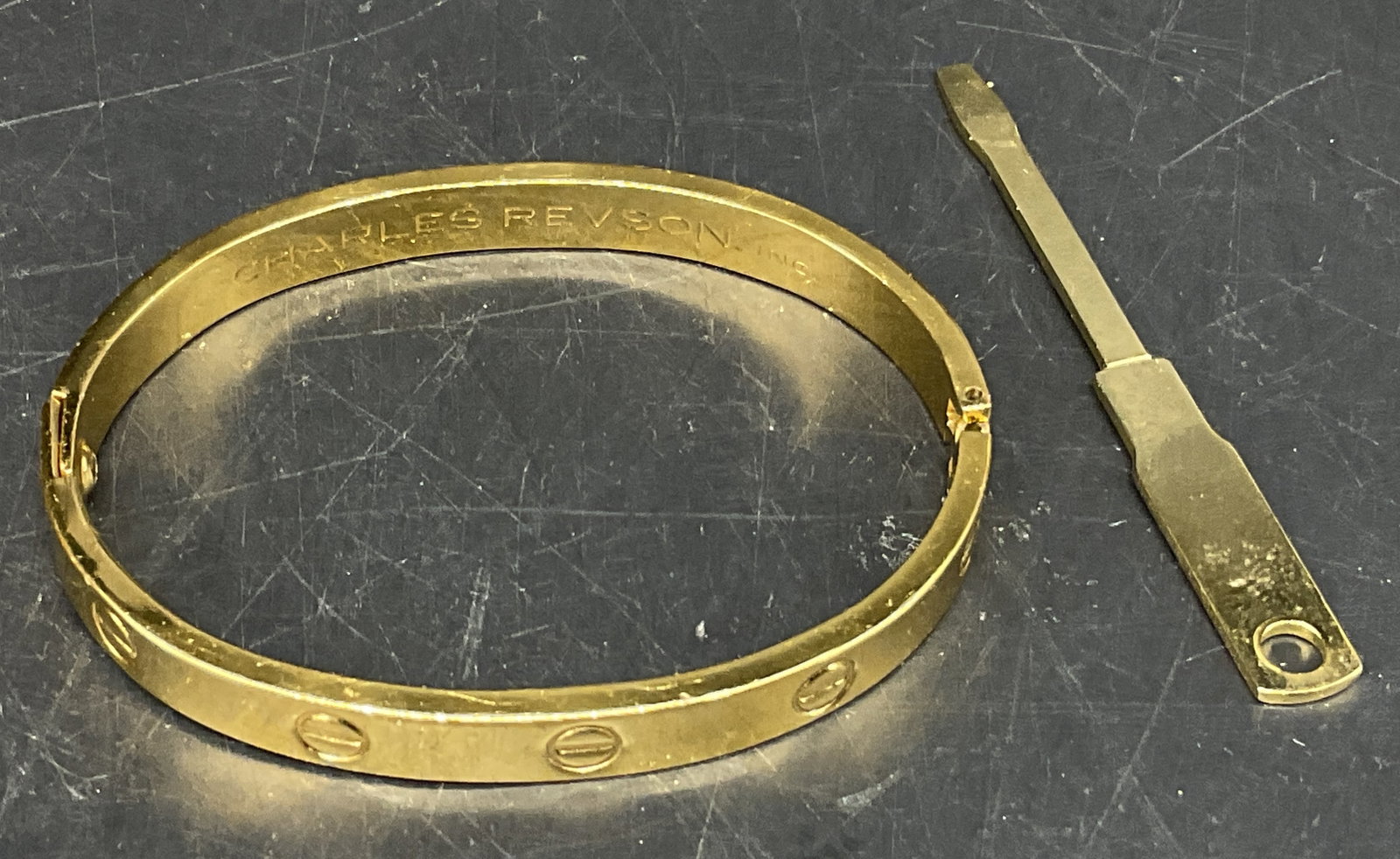 70 Charles Revson &Aldo Cipullo Gld Elec Bracelet: Vintage 1970 Charles Revson Inc Gold Electroplate Romantic Bracelet. Designed by Aldo Cipullo. Comes with Key to Lock to Wrist. Scratching Present. Measures app 2.25in Diam. Vintage Bracelets, 1970, C