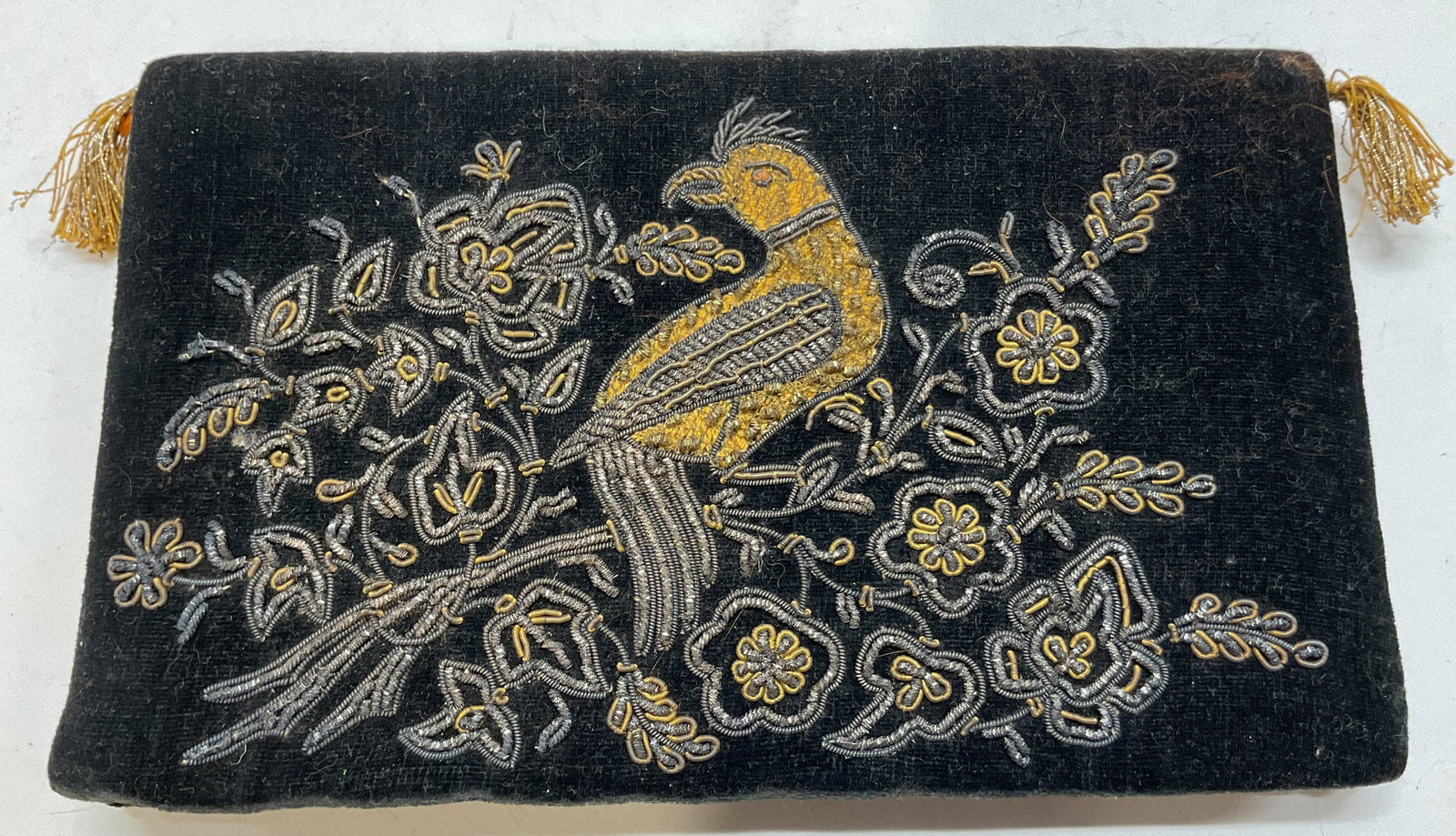 Vintage Black Silk Beaded Bird Evening Clutch: Vintage black silk beaded bird evening clutch. Rectangular shape. Beaded floral and bird motifs in varying colors. Attached handle with fringed accent. Button closure on backside. Inside