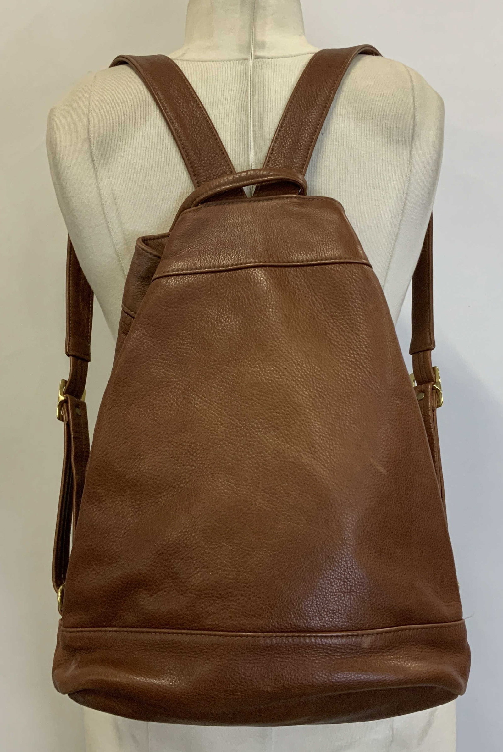 Sven Berkeley Brown Leather Backpack USA: Sven Berkeley brown leather backpack features gold toned buckle & adjustable shoulder straps. Signed & marked. Reads, SVEN BERKELEY USA. Surface wear consistent to age, use & exposure. Measurements: h