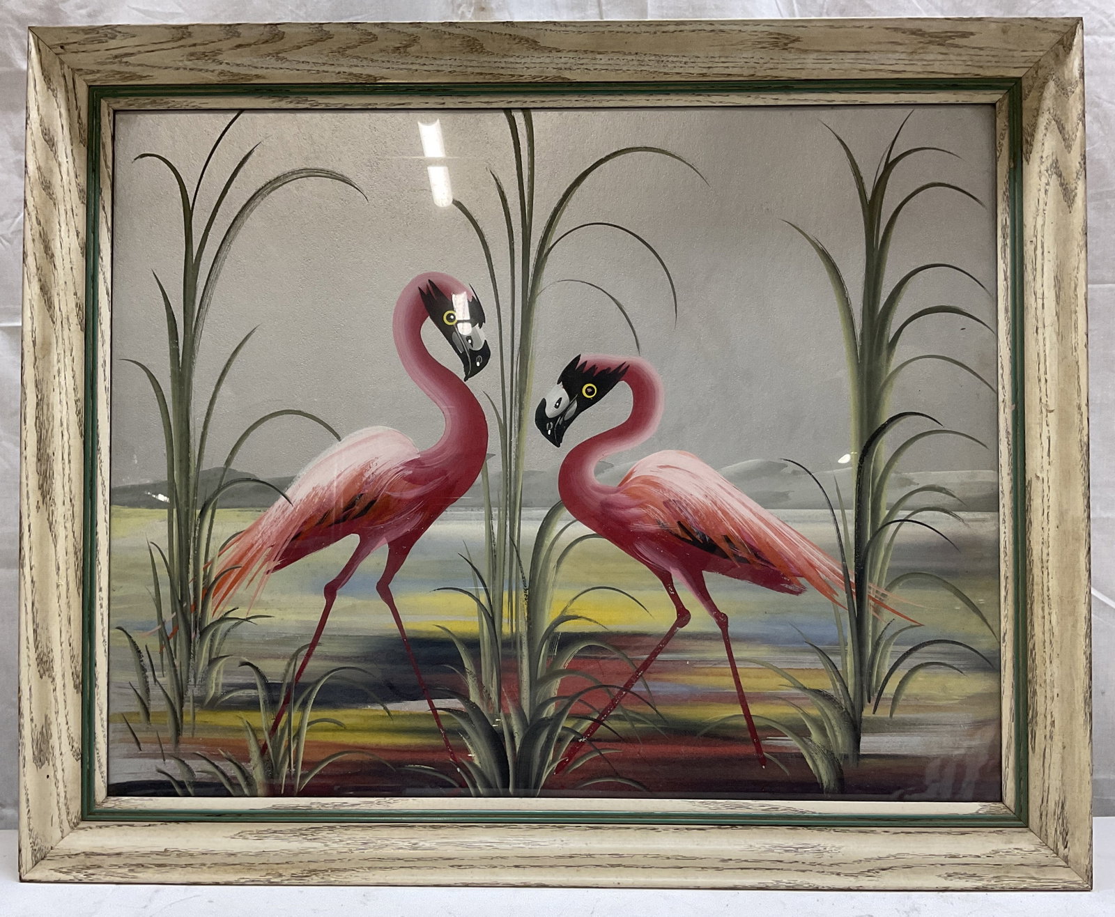 M Devoe Framed Acrylic Flamingo Painting: M Devoe framed acrylic flamingo painting. Framed in a whitewashed wood frame. Metallic board backing. Depicts stylized flamingoes amidst tall reeds. Varying colors. Tropical art piece. Measures approx