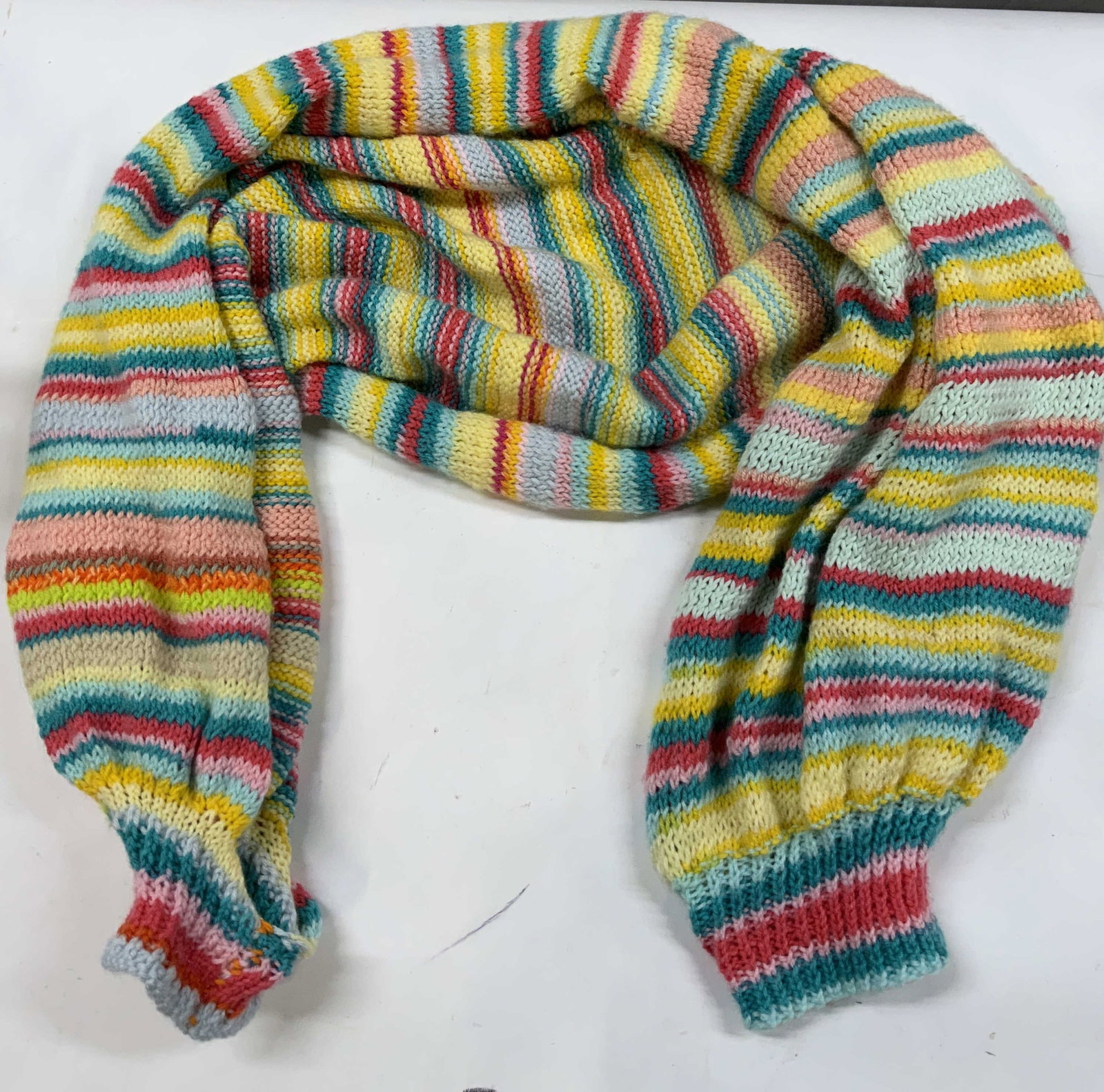 Vntg multi-striped knit bolero with cuffs: Vintage multi-striped knit bolero with cuffs. The piece is worked flat in a stockinette stitch pattern , shifting between various shades of pink, turquoise, green and yellow stripes. The ends are fini