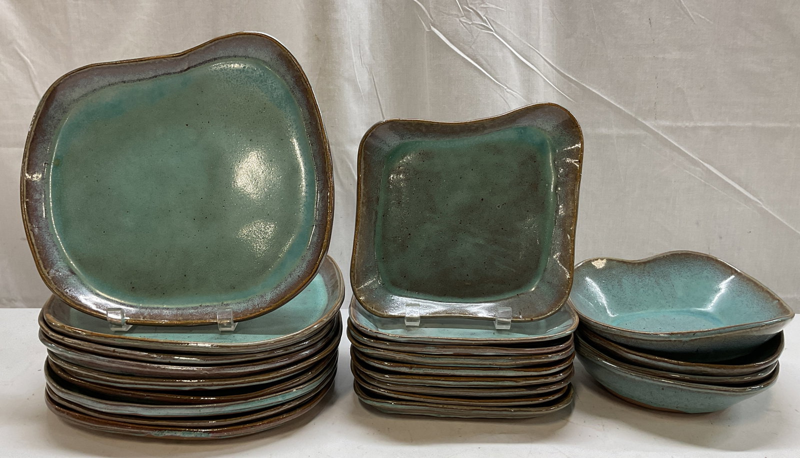 Set 22 Vintage Blue Stoneware Tableware: 22 piece vintage blue stoneware tableware set. Signed on underside. Includes 9 dinner plates, 9 lunch plates, and 4 bowls. Unique shapes and scalloped design. Blue glazed, glossy finish. Undersides ar