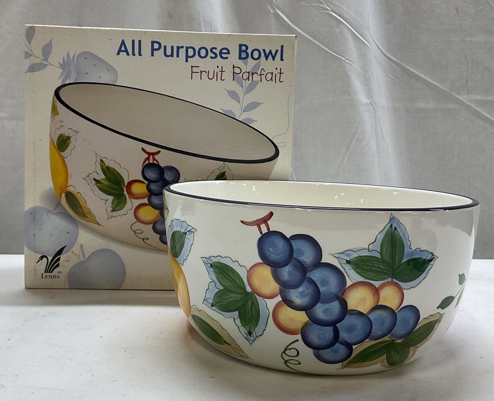 Lynns Fruit Parfait All Purpose Bowl W OG Box: Lynns Fruit Parfait earthenware all purpose bowl. Comes in original box. Marked on underside, reads Lynns Earthenware. Round bowl with blue rim. Hand painted fruit motifs in varying colors. Glossy fin